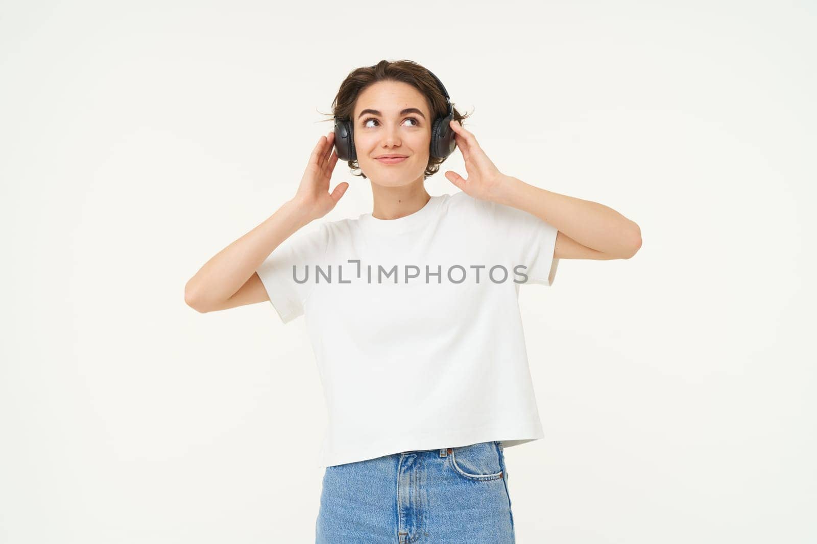 Portrait of smiling young woman, listening to music, enjoying dancing to favourite song, isolated on white background by Benzoix