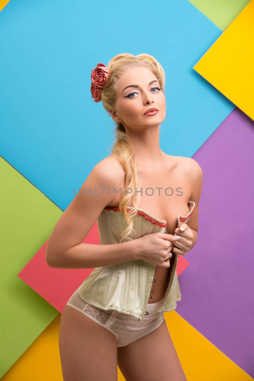 Romantic sexy pin up girl wearing beige lingerie cropped shot against colorful background