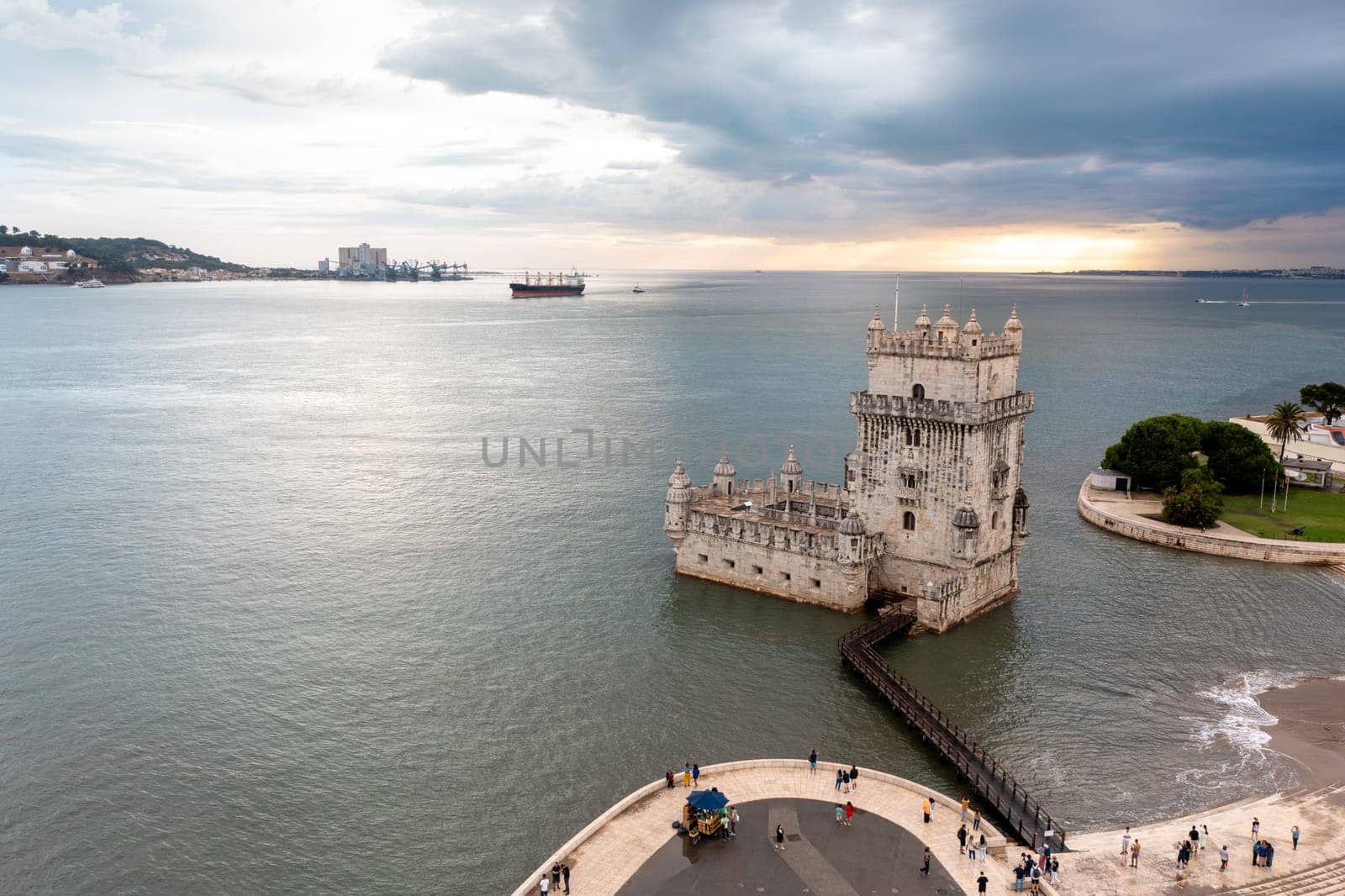 Aerial view Belem Tower. Fortress monument in Lisbon on Tagus River. 16th-century fortification Torre de Belem in city under cloudy sky.