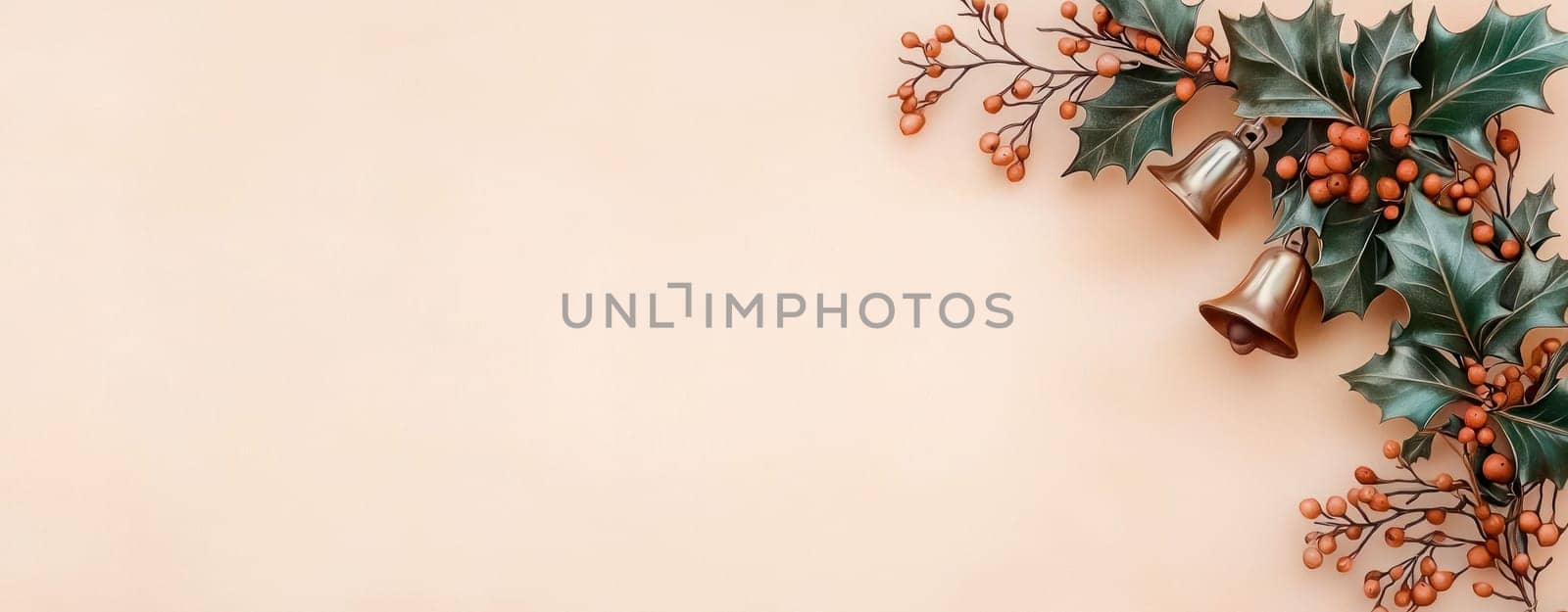 Festive holly and golden bells on soft pastel background create warm atmosphere.