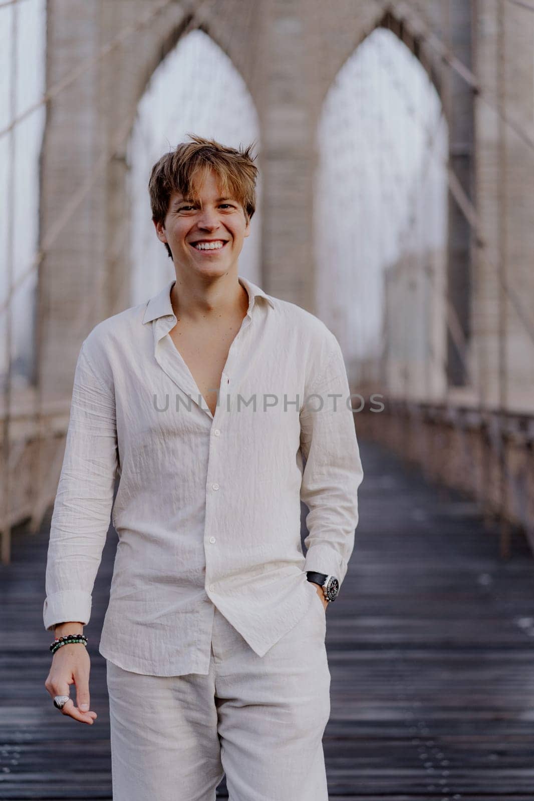 A vibrant young man enjoys a blissful moment on the iconic Brooklyn Bridge, showcasing his urban style