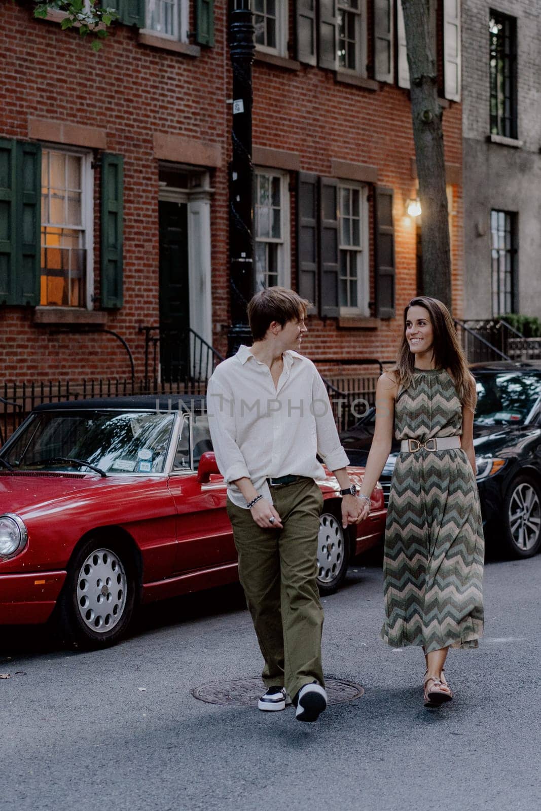 A lovely couple strolls hand in hand through a serene urban setting, harmoniously capturing love amidst nature