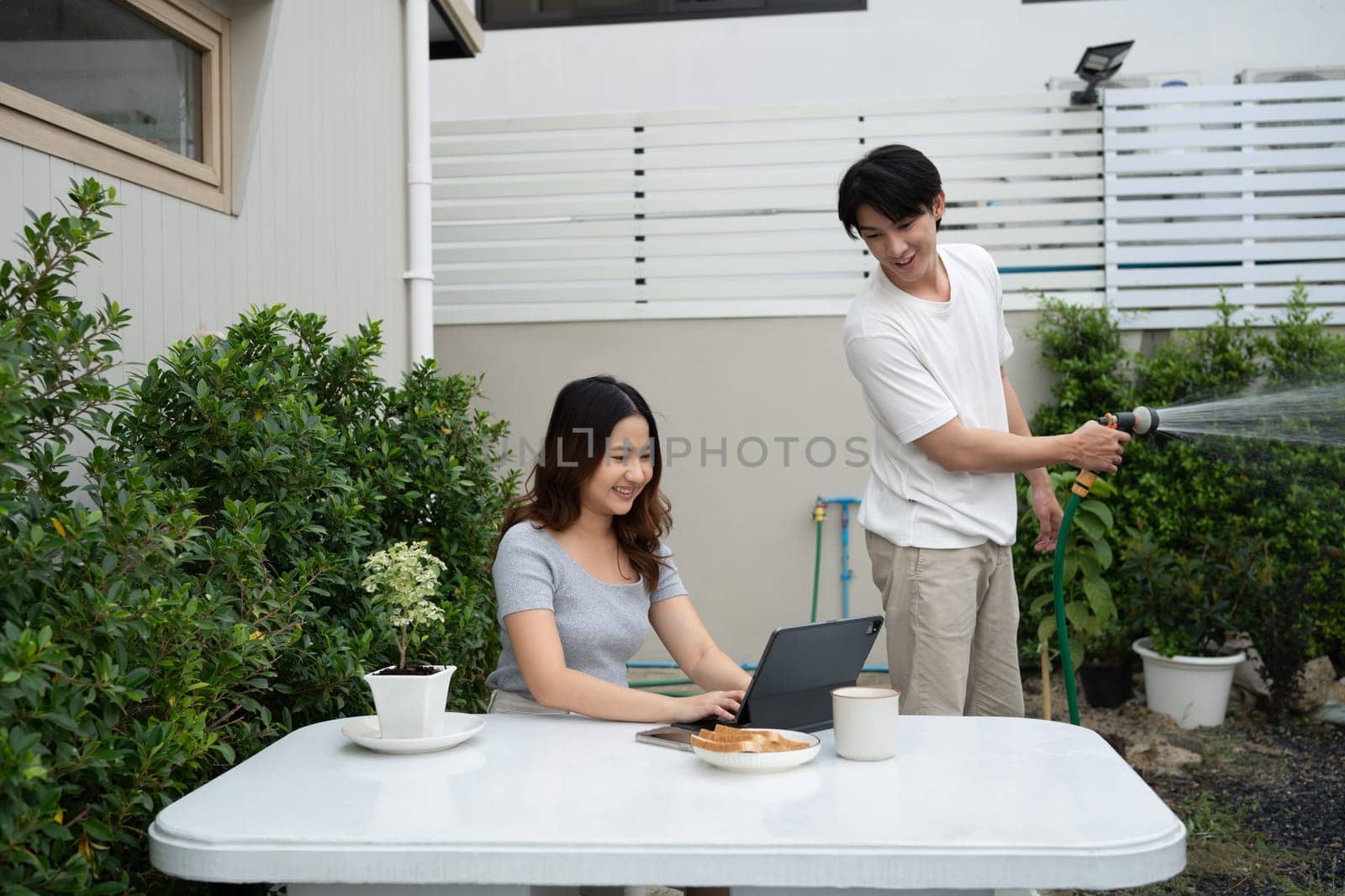 Cheerful asian couple relaxing together in a garden.