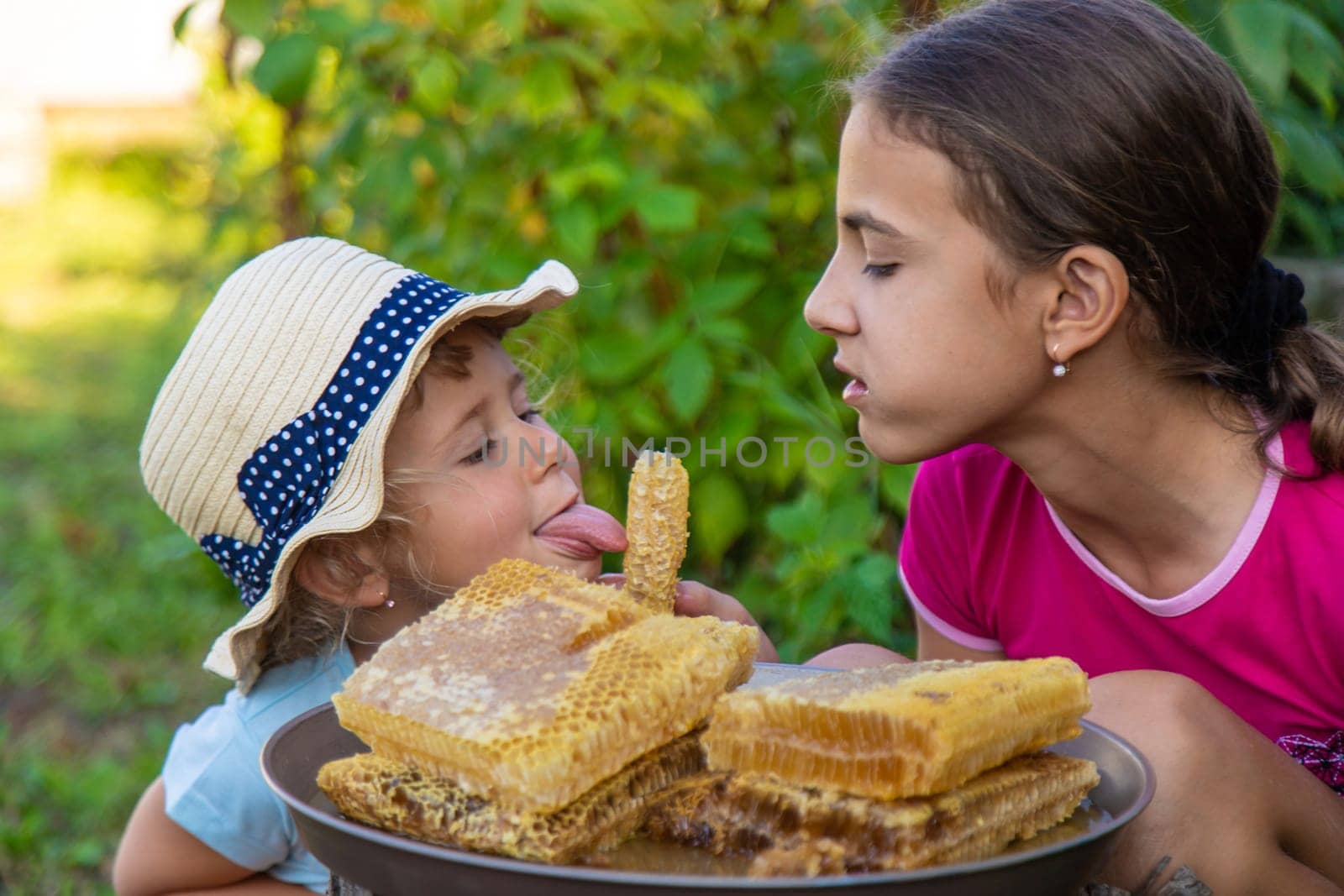 A child eats honey from a comb. Selective focus. Kid.