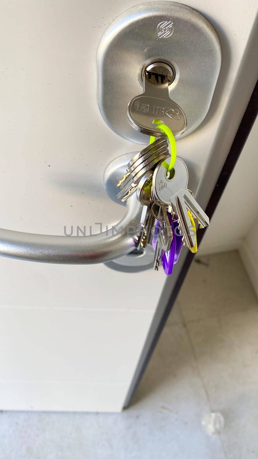 Cremona, Lombardy, Italy October 15th 2024 Bunch of keys hanging from keyhole on white door, concept of security, house, and ownership