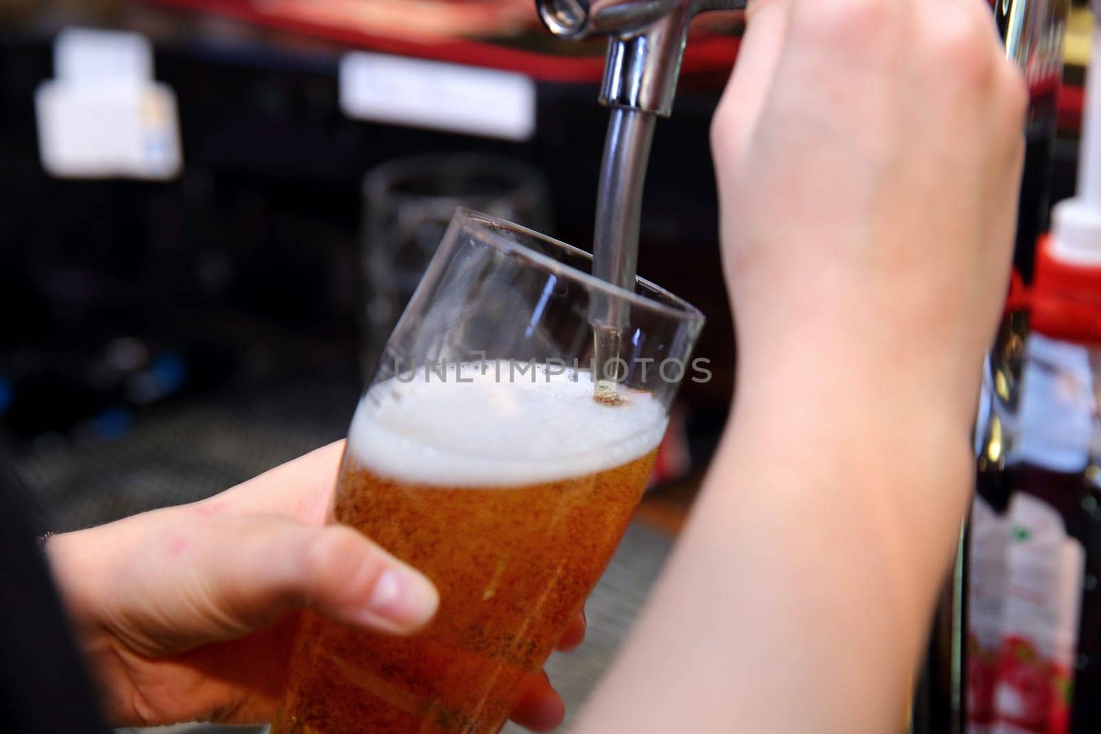 A bartender pours a cold glass of beer, showcasing warmth and hospitality in a vibrant, inviting bar