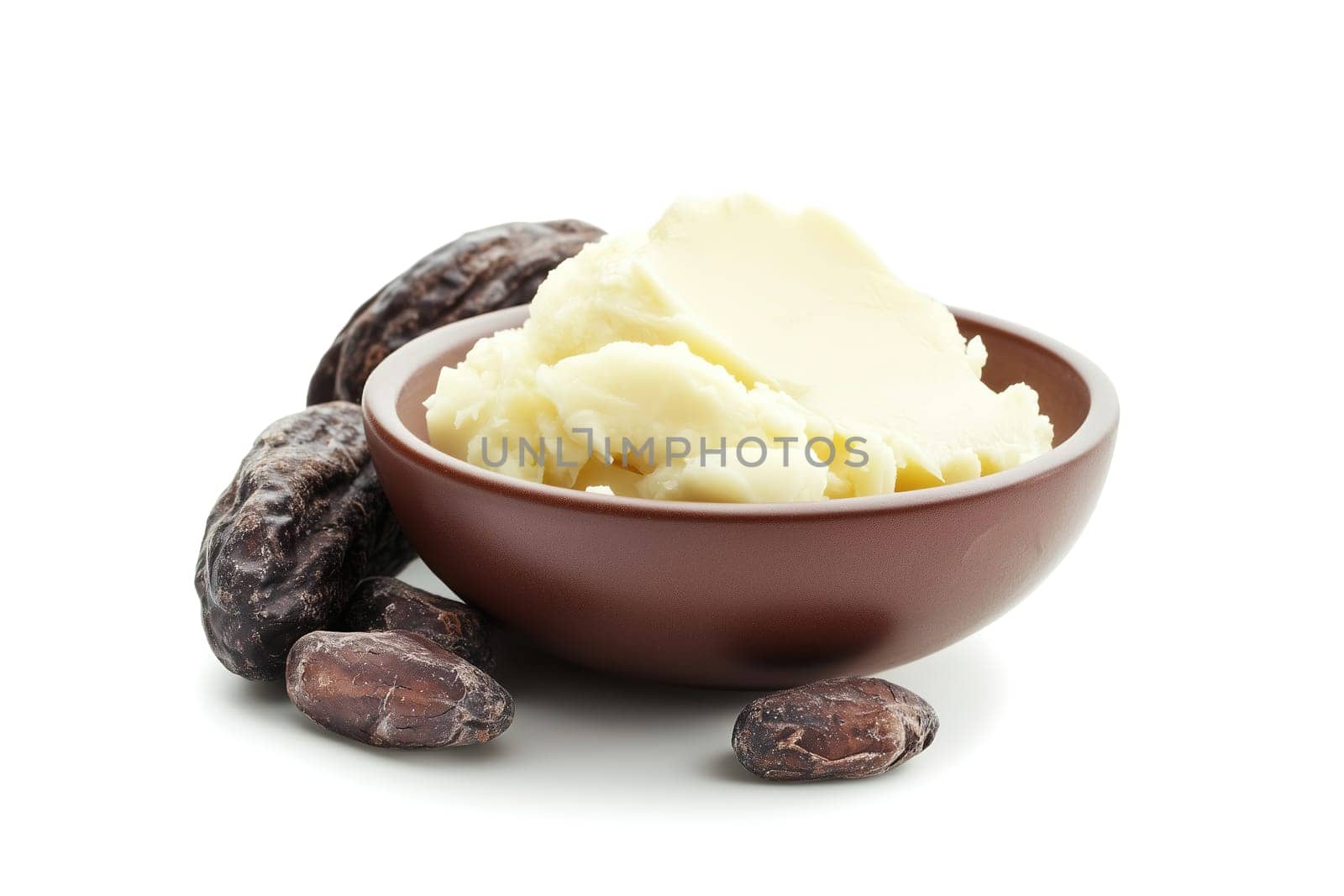 A bowl filled with creamy natural shea butter is placed beside several raw cocoa seeds. The setup emphasizes the ingredients' organic origins for skincare and cosmetic purposes.