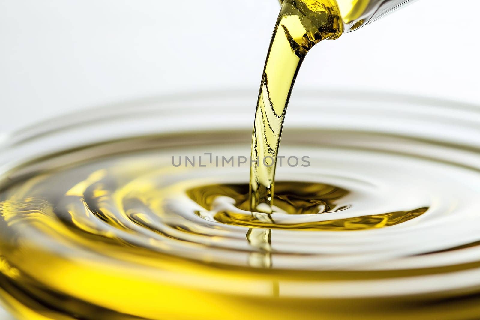 A stream of golden oil cascades into a circular pool, creating ripples on the surface. The liquid shines under bright light, showcasing its vibrant hue and smooth consistency.