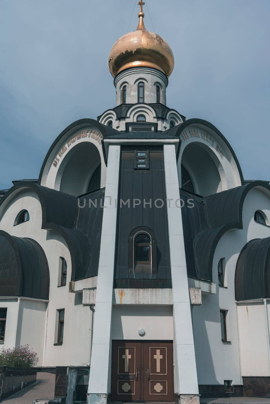 Ornate Orthodox church with a golden dome and intricate arched architectural details, symbolizing Eastern Orthodox tradition against a soft sky