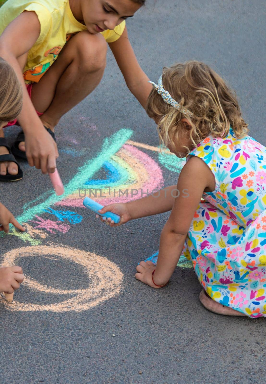 Children draw with chalk on the asphalt. Selective focus. kid.