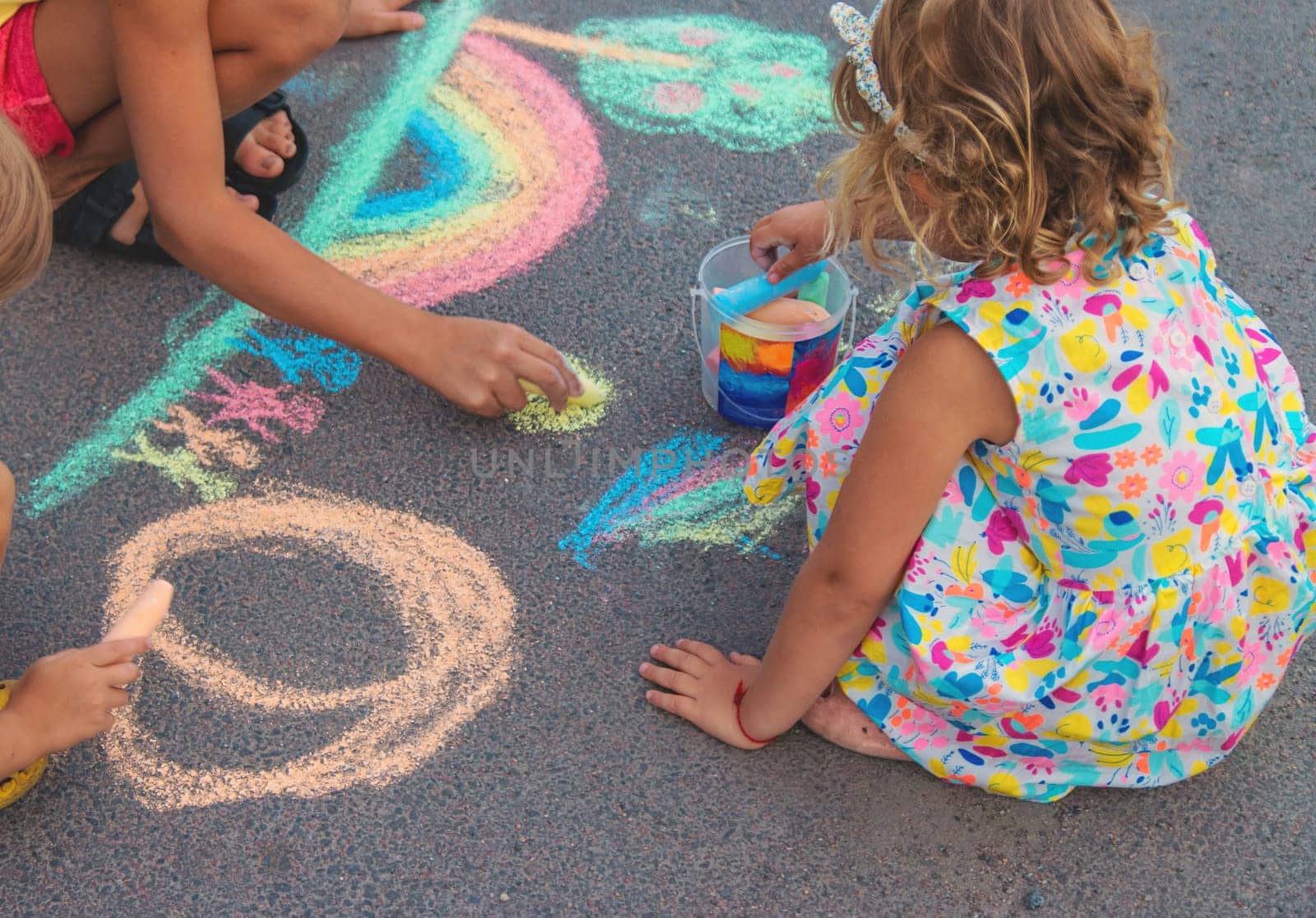 Children draw with chalk on the asphalt. Selective focus. kid.