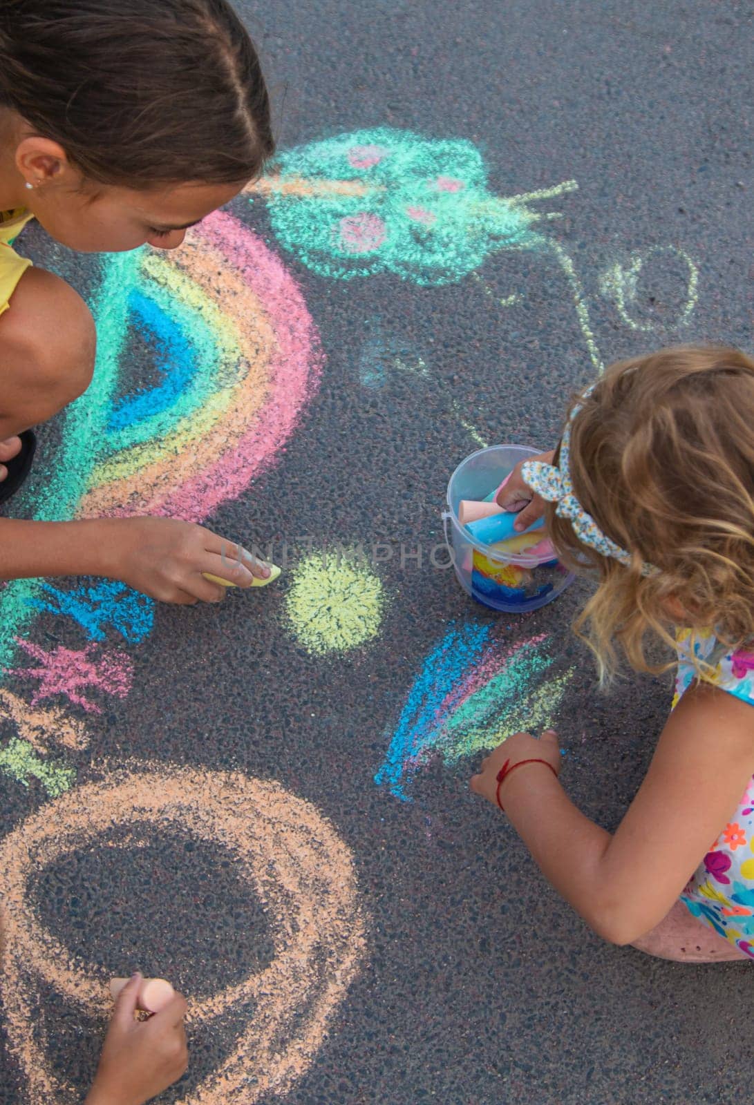 Children draw with chalk on the asphalt. Selective focus. kid.