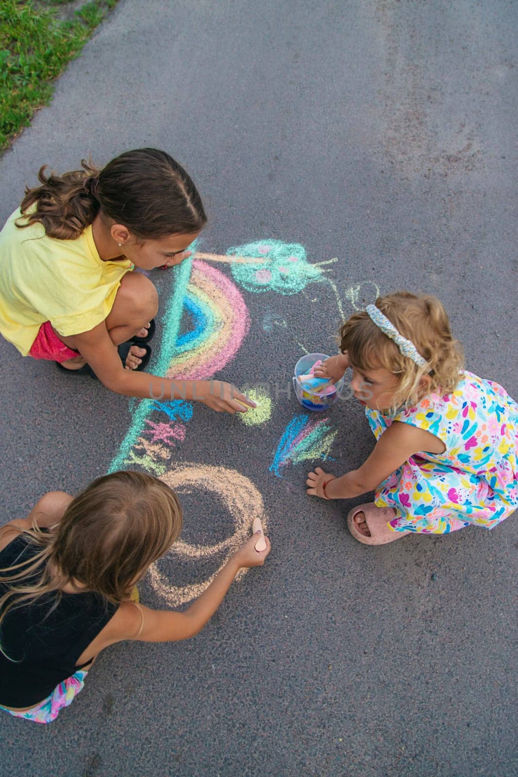Children draw with chalk on the asphalt. Selective focus. kid.