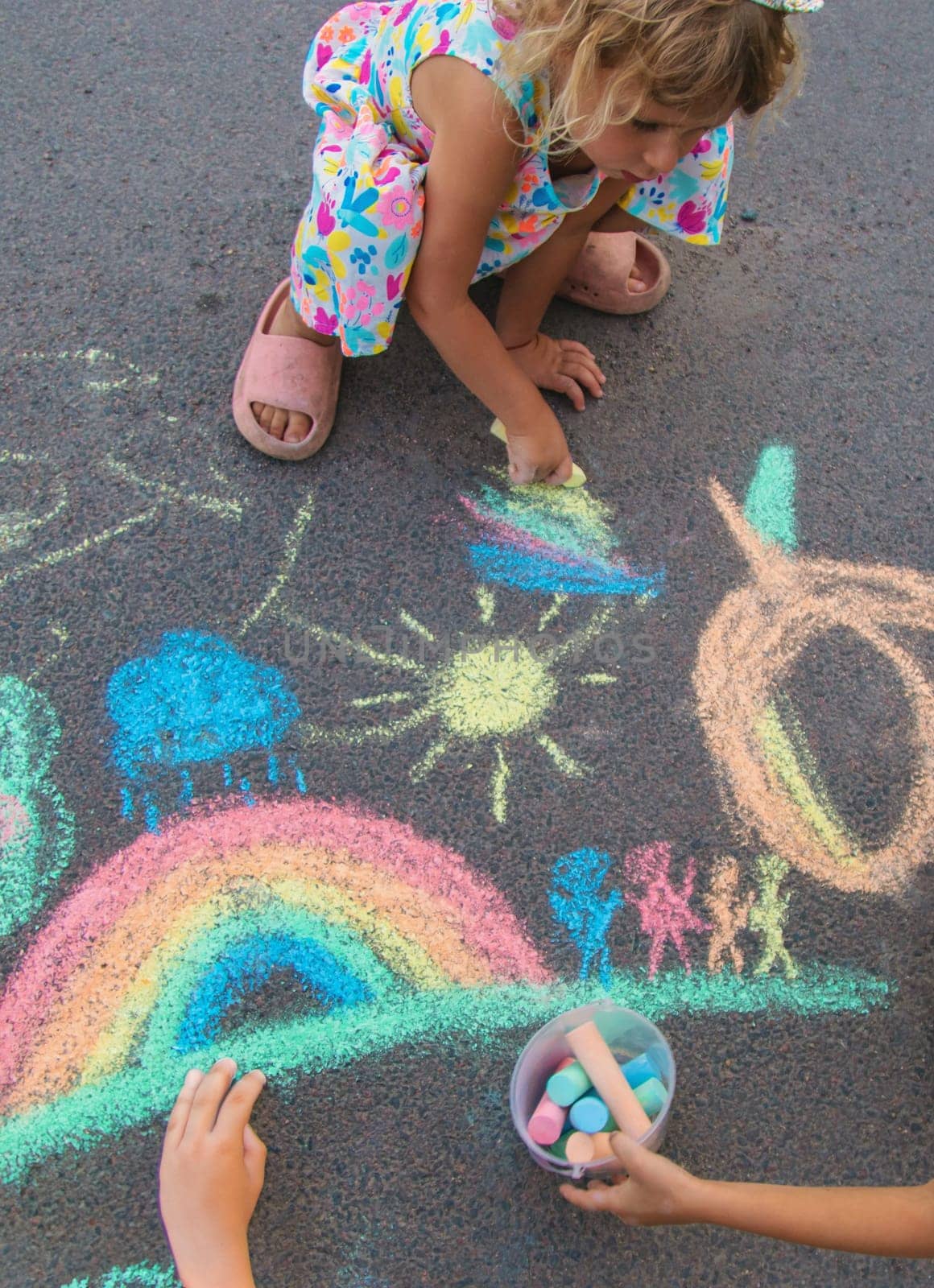 Children draw with chalk on the asphalt. Selective focus. kid.