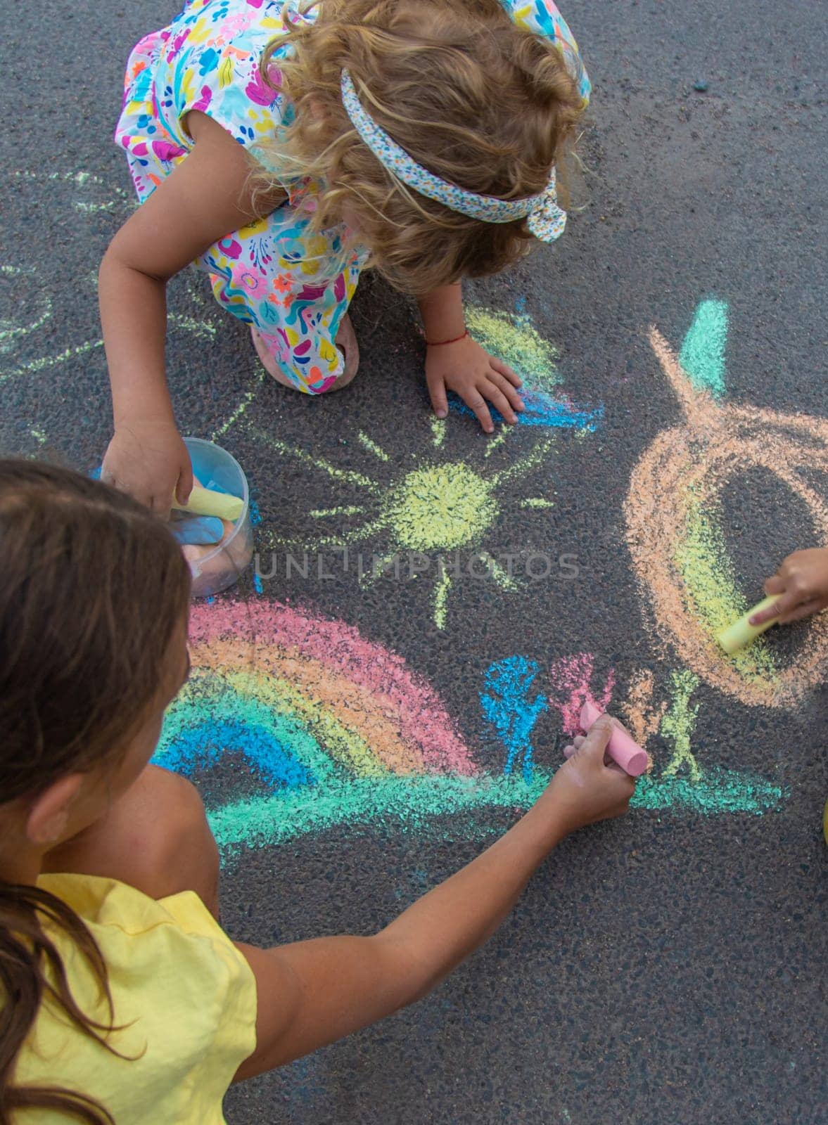 Children draw with chalk on the asphalt. Selective focus. kid.
