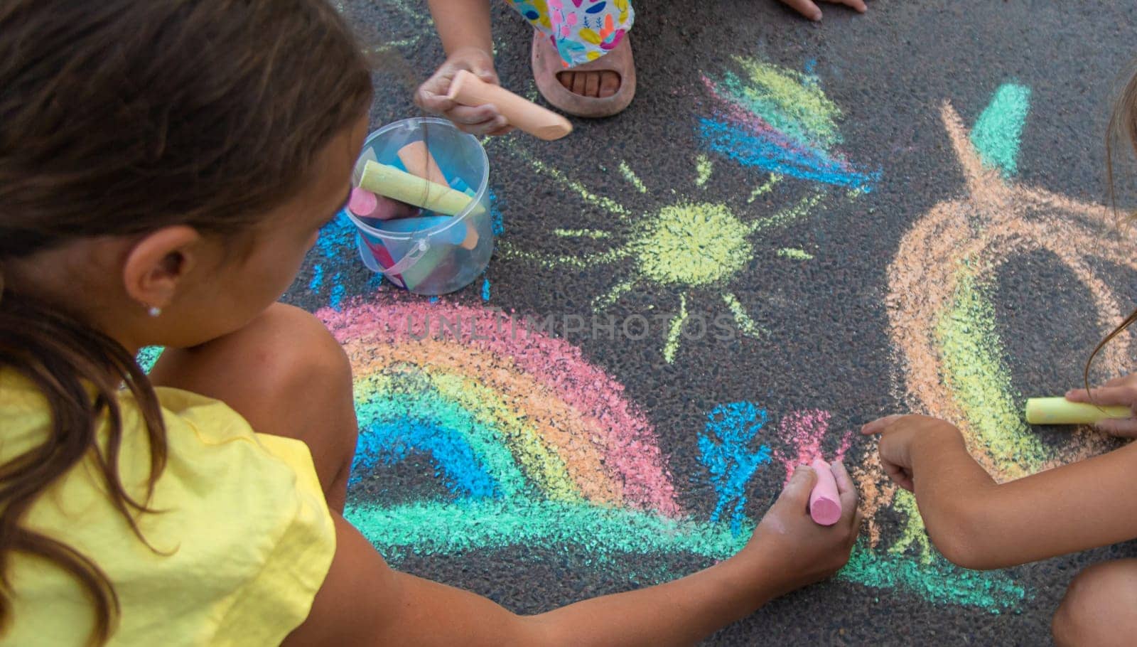 Children draw with chalk on the asphalt. Selective focus. kid.