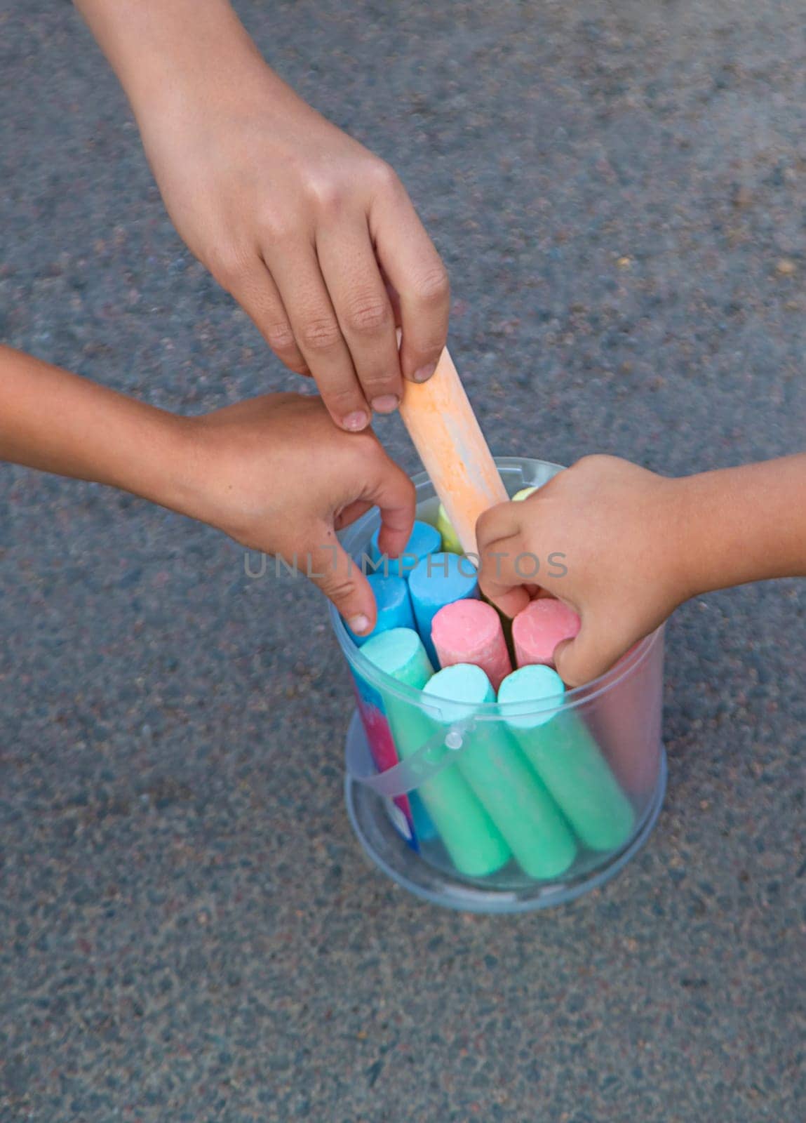 Children draw with chalk on the asphalt. Selective focus. kid.