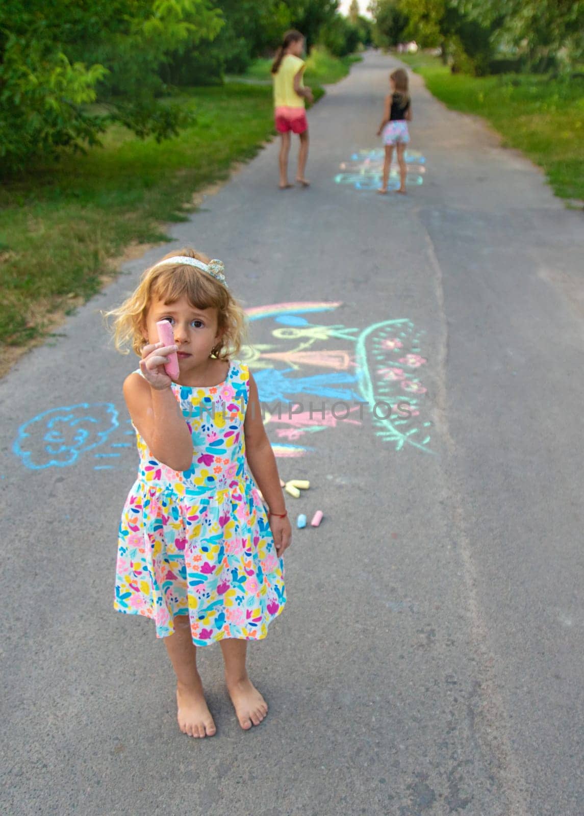 Children draw with chalk on the asphalt. Selective focus. kid.