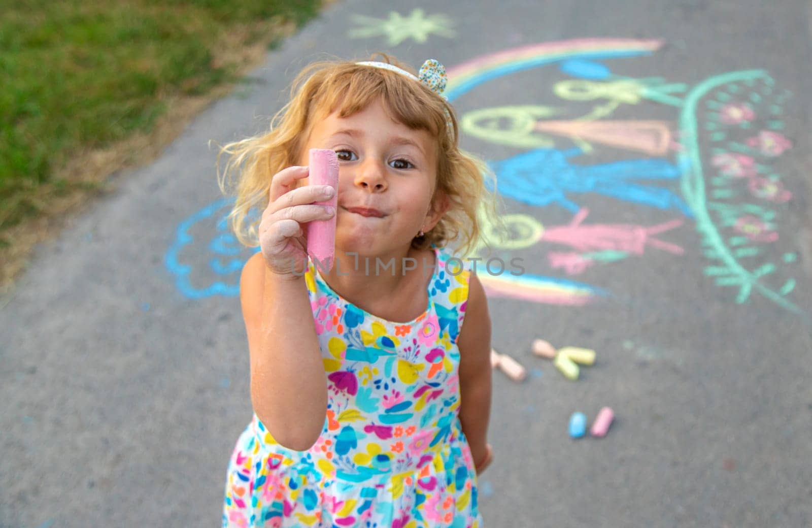 Children draw with chalk on the asphalt. Selective focus. kid.