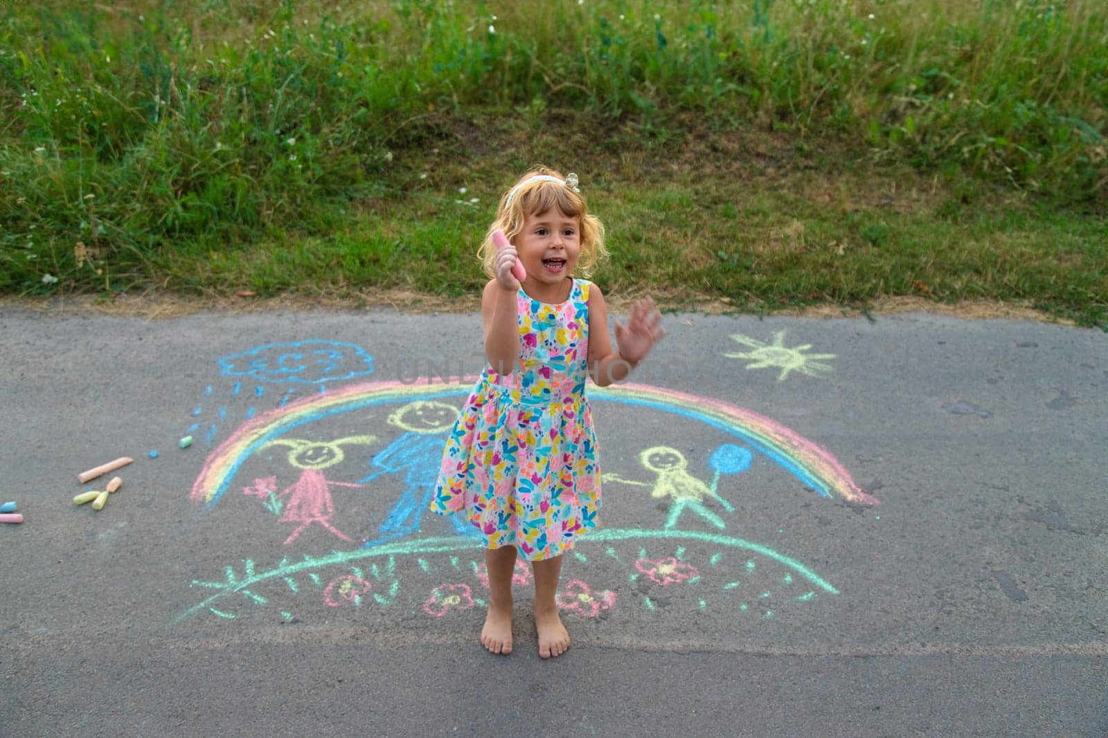 Children draw with chalk on the asphalt. Selective focus. kid.