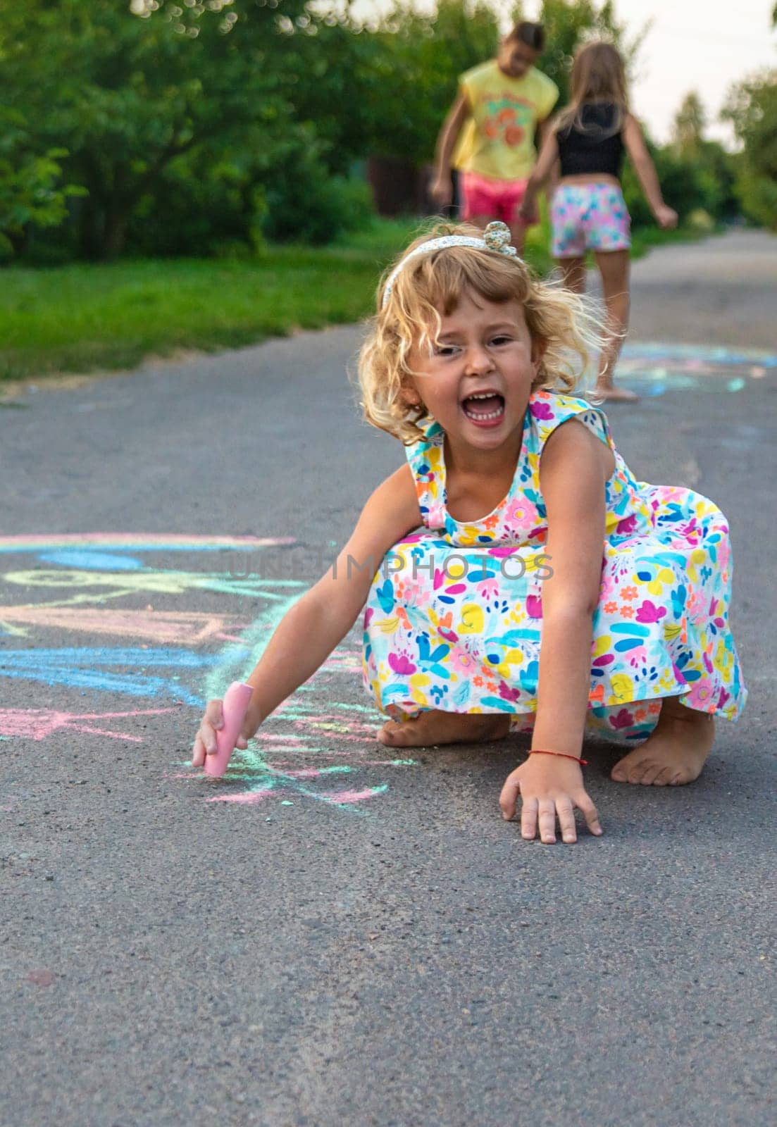 Children draw with chalk on the asphalt. Selective focus. kid.