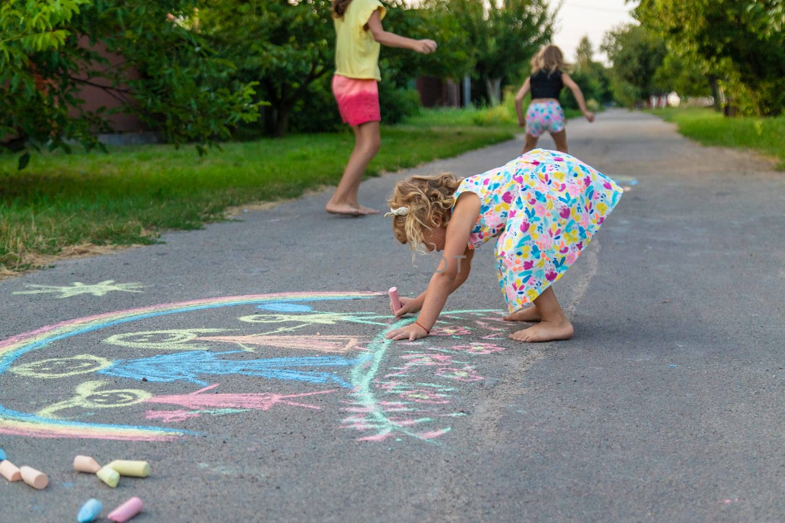 Children draw with chalk on the asphalt. Selective focus. kid.