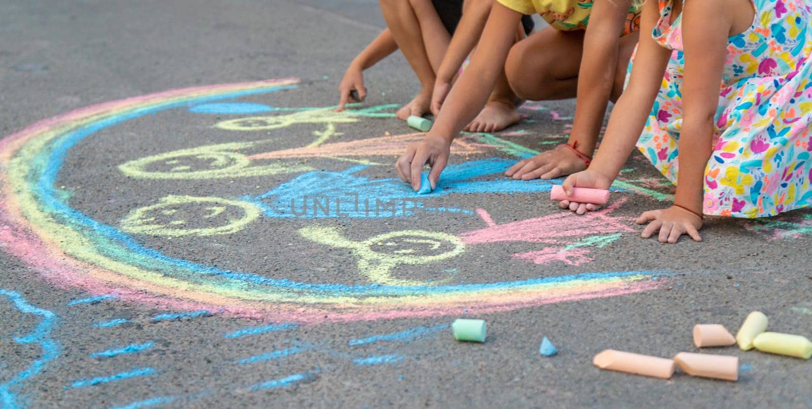 Children draw with chalk on the asphalt. Selective focus. kid.