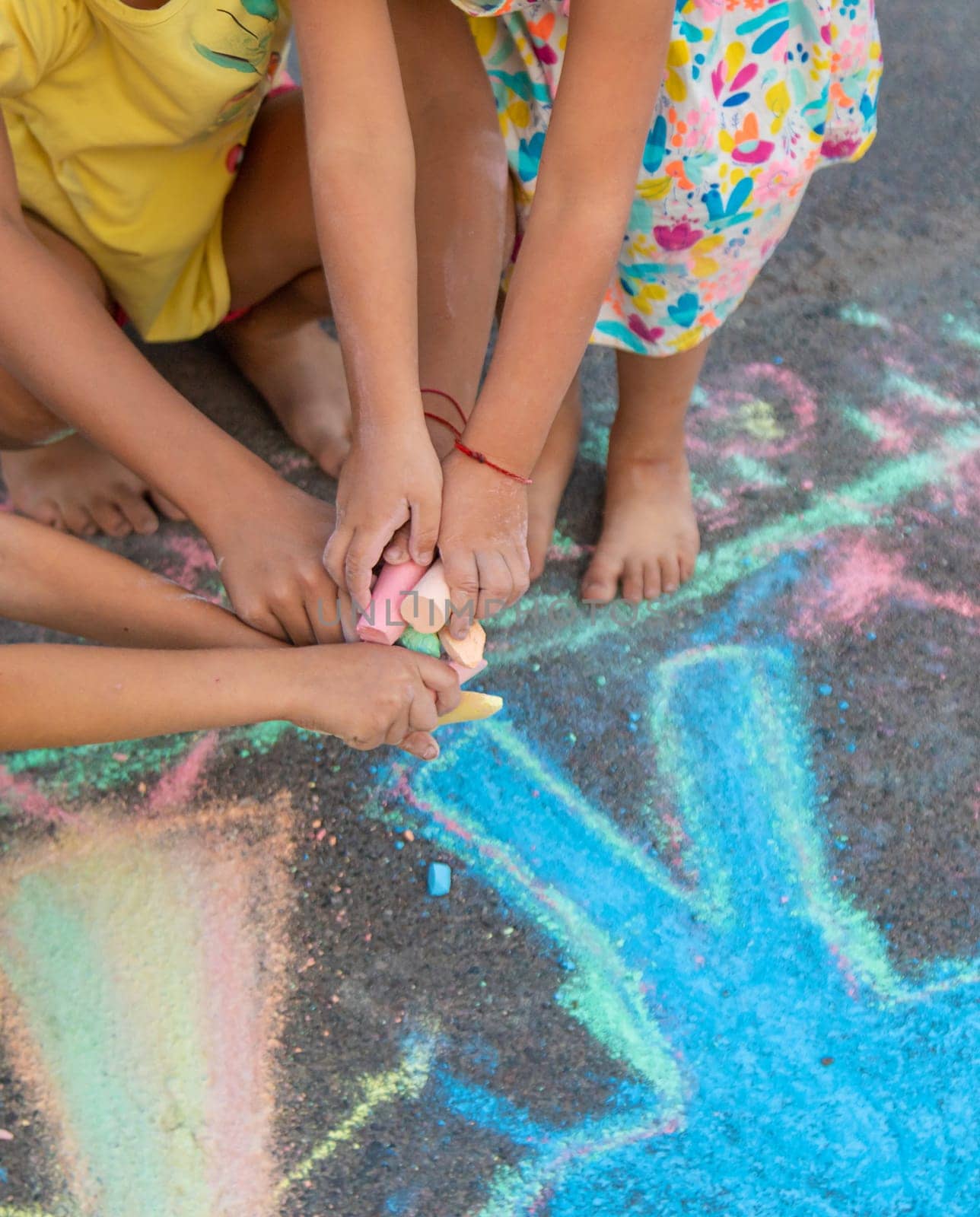 Children draw with chalk on the asphalt. Selective focus. kid.