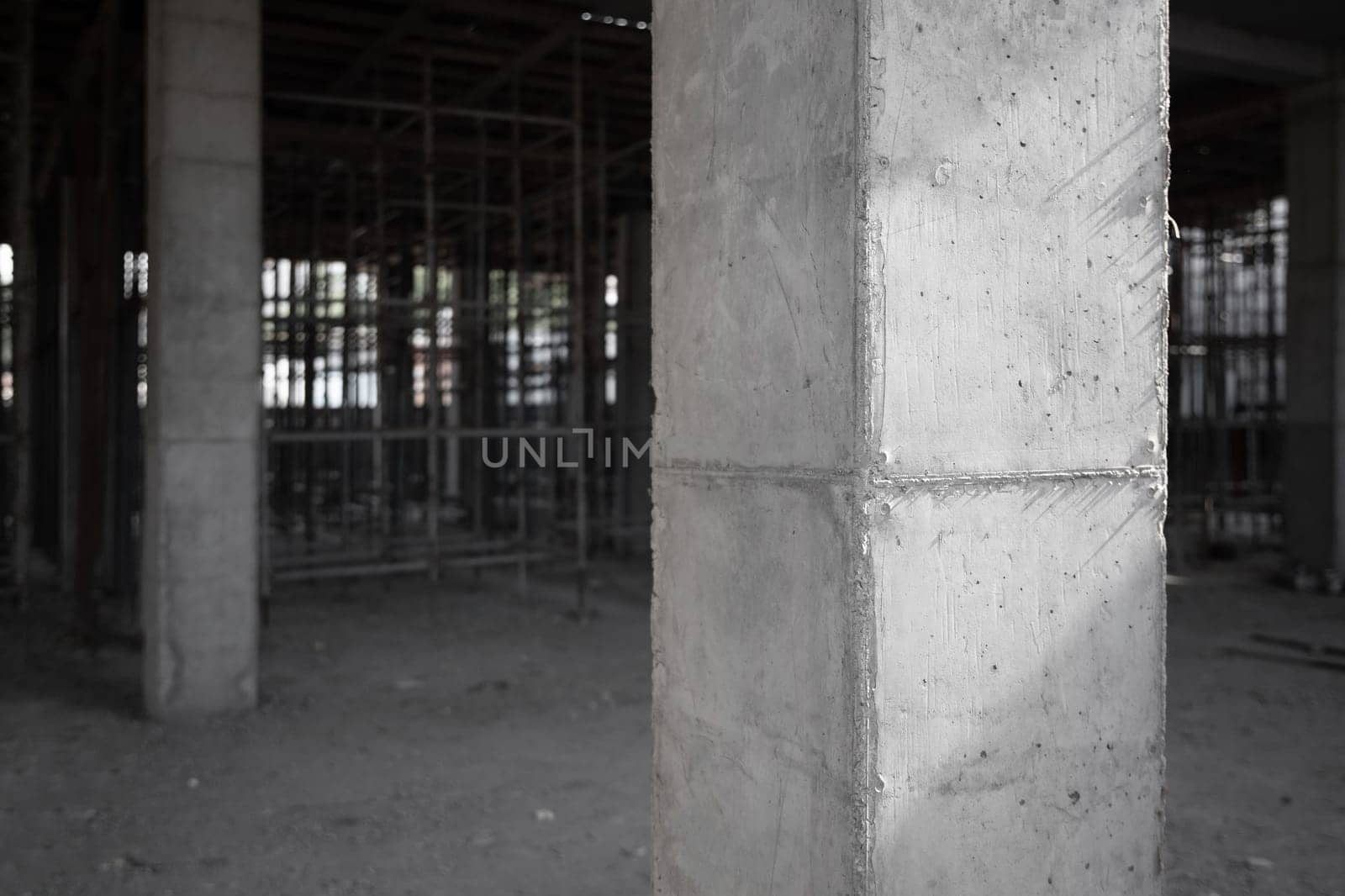 Amidst scaffolding, a fortified concrete column stands as the foundation for pouring concrete to lay the groundwork for the building's ongoing construction.