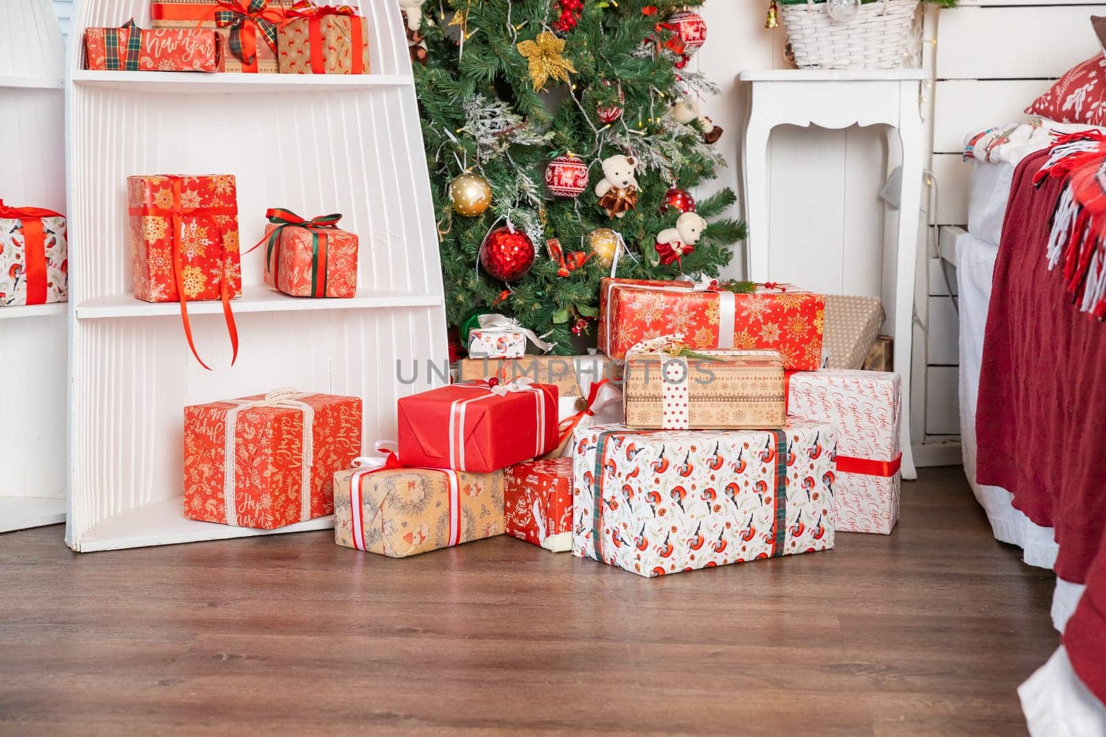 Stylish wrapped christmas gifts with ribbon on table on background of decorated christmas tree