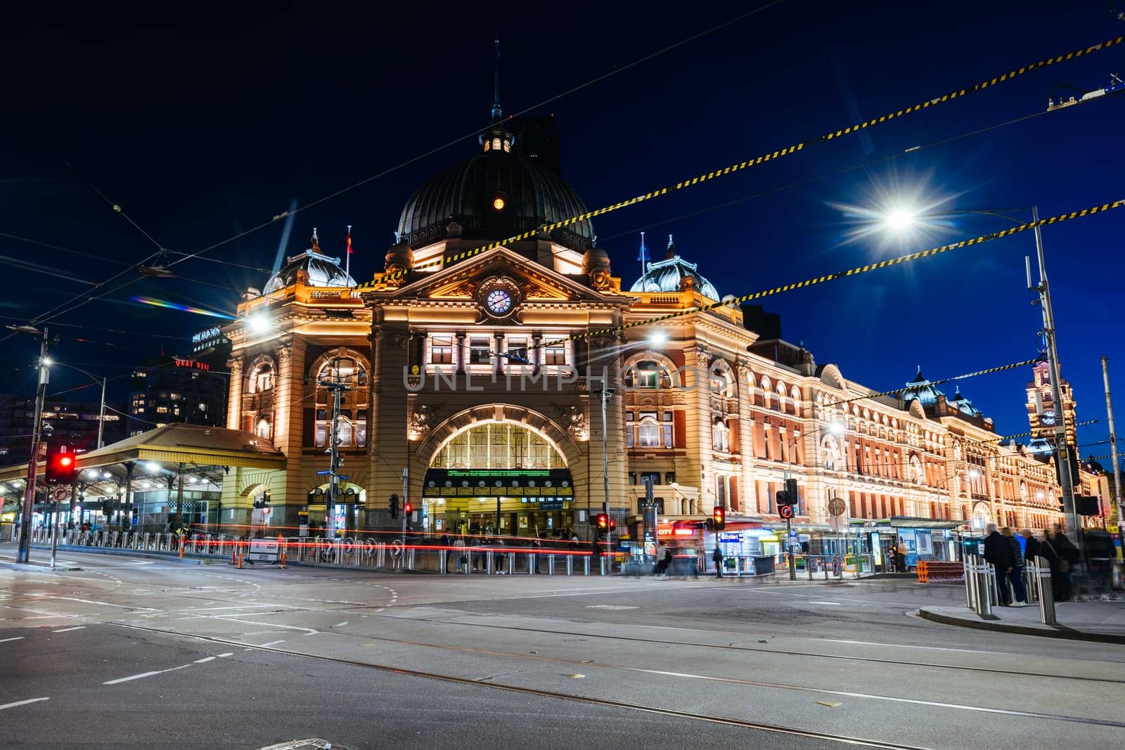 MELBOURNE, AUSTRALIA - OCTOBER 10, 2024: Melbourne's Flinders Station at dusk and rush hour with traffic and pedestrians on October 10th, 2024