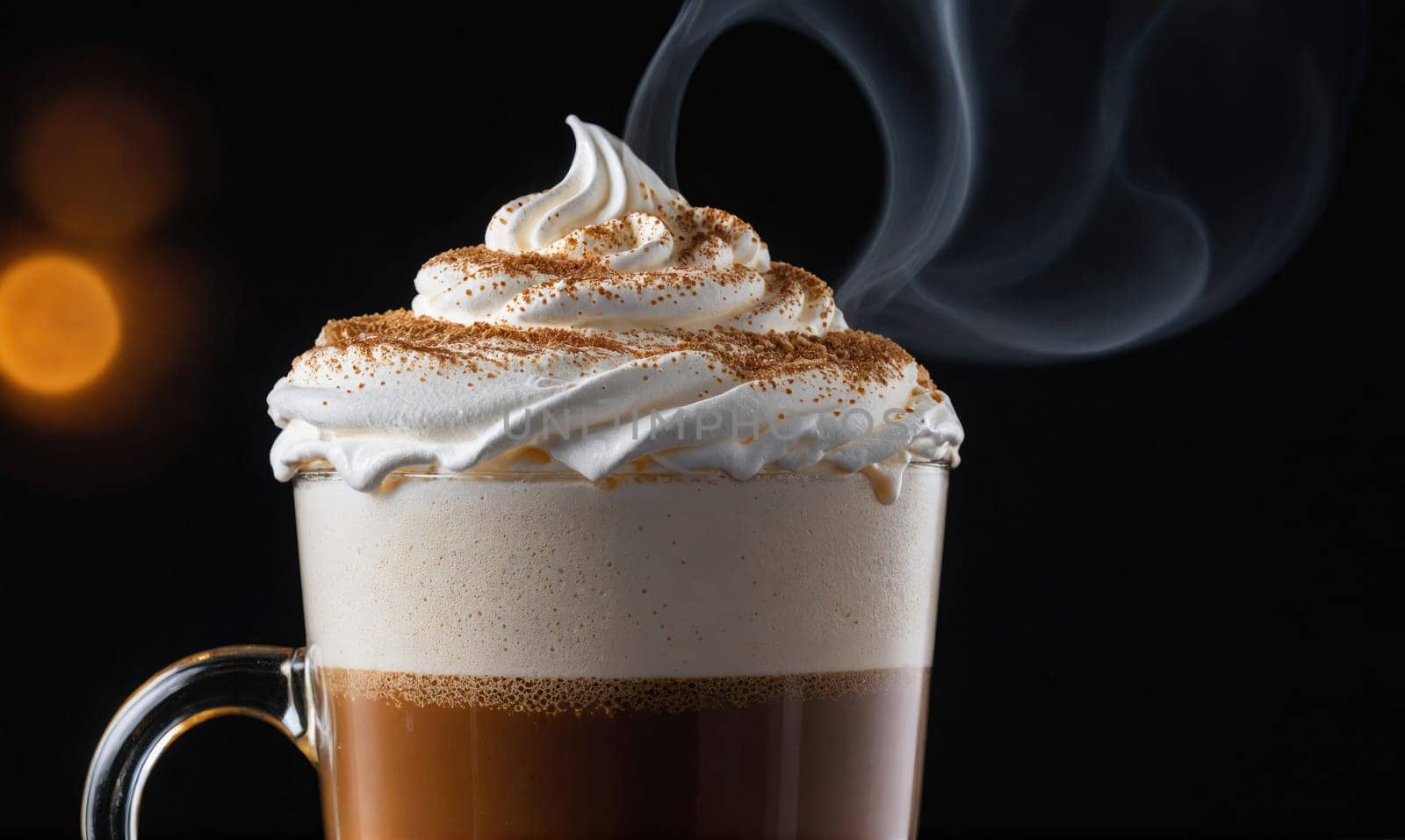 A close-up of a tall glass mug filled with coffee. The coffee is topped with a thick layer of whipped cream and a sprinkle of cinnamon.