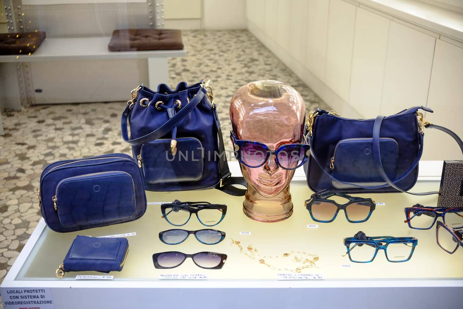 Cremona, Lombardy, Italy - November 7th 2024 Stylish accessories including sunglasses, handbags, and eyeglasses are displayed in a shop window, showcasing the latest fashion trends