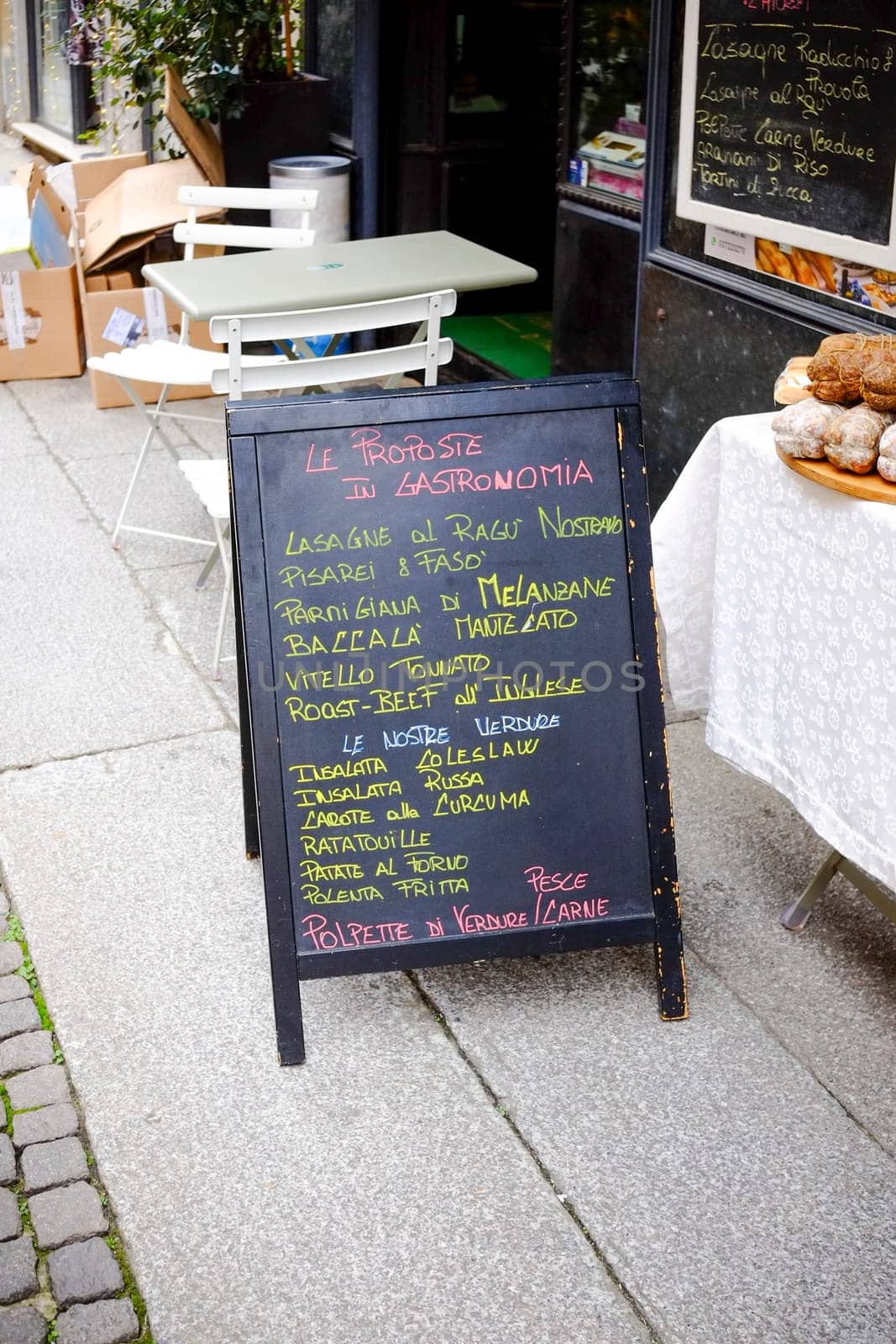 Cremona, Lombardy, Italy - November 7th 2024 Chalkboard menu stands on the sidewalk outside an italian restaurant, displaying a variety of traditional dishes