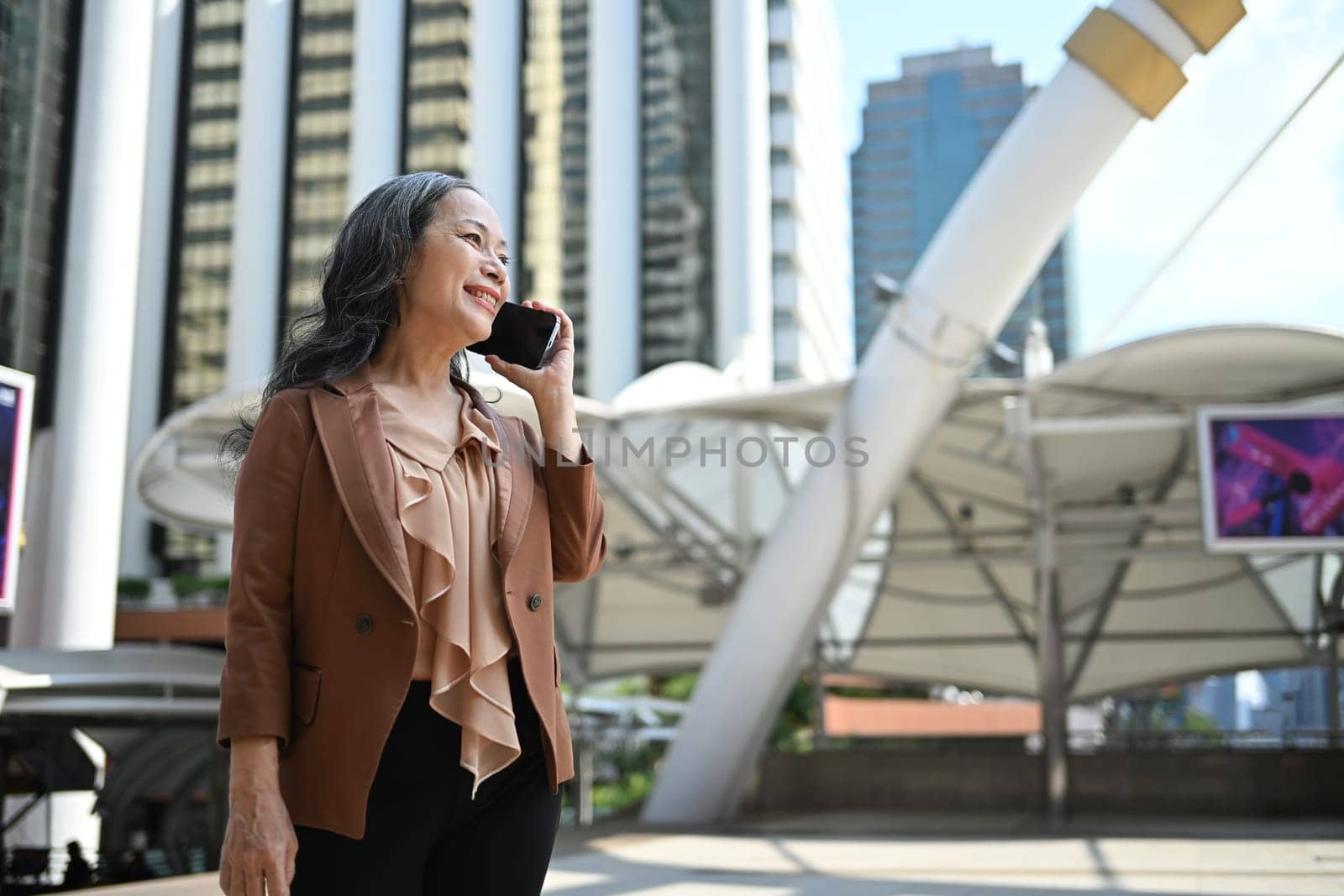 Successful senior woman enjoying a conversation in a modern urban.