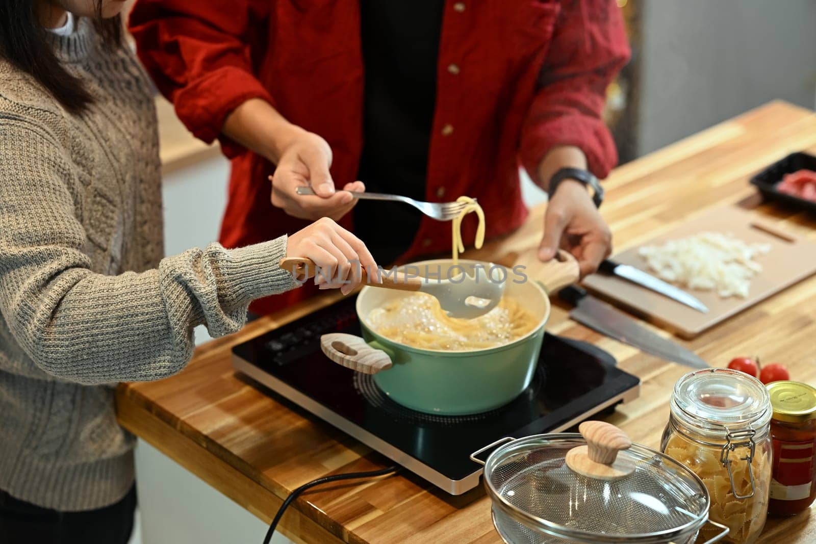 Young married couple making pasta together during the festive season.