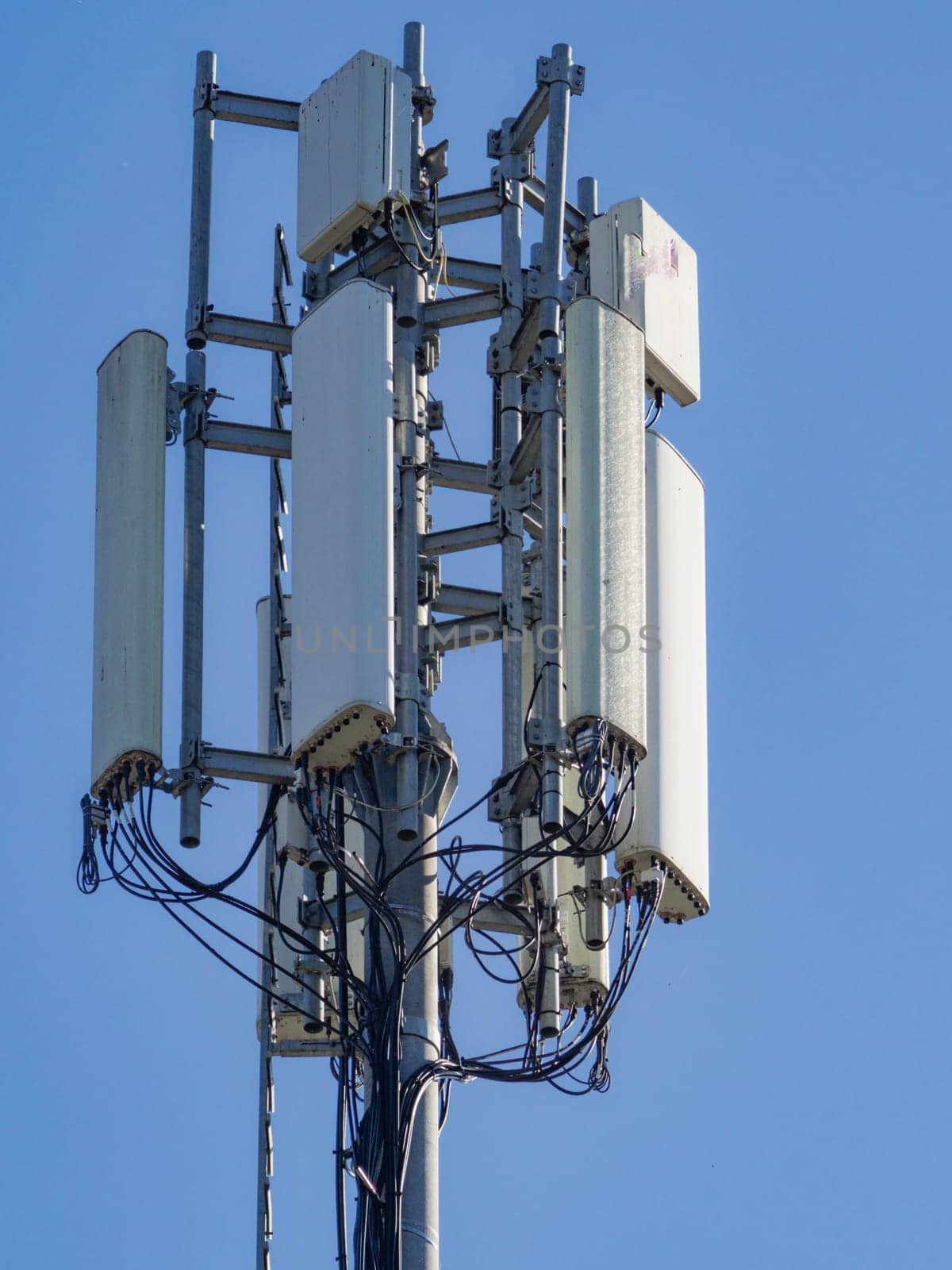Telecommunication tower stands tall against a clear blue sky, broadcasting signals for mobile communication and internet connectivity, ensuring seamless communication in the modern world