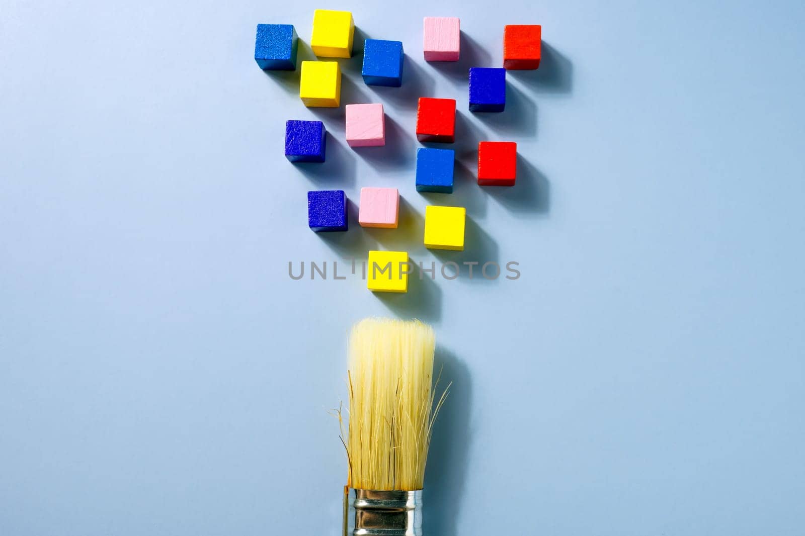 A brush and multi-colored cubes as symbol of creativity and a non-standard approach. by designer491