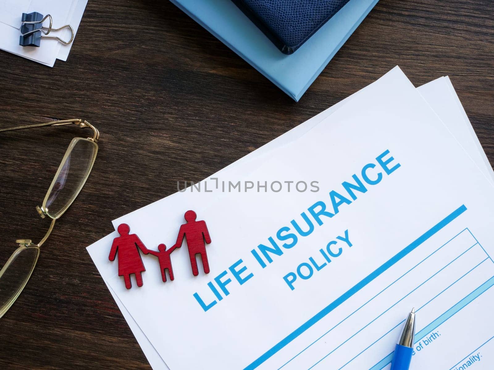 Life insurance policy and figurines of family. by designer491