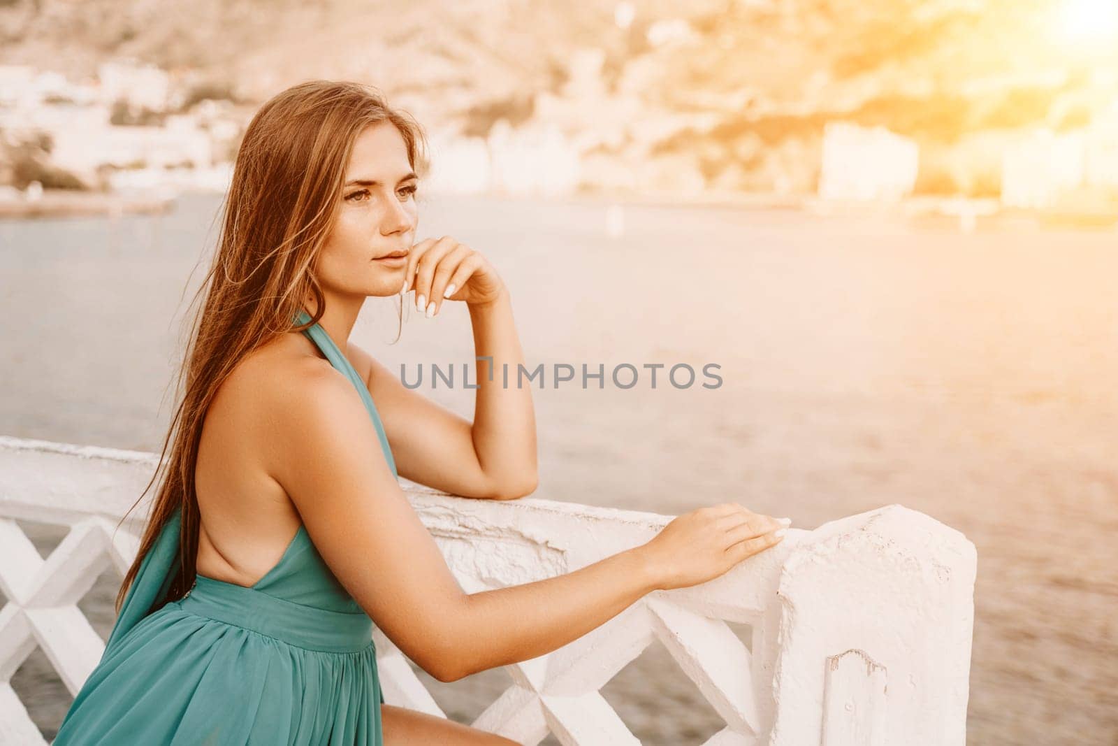 Woman sea trevel green dress. Side view a happy woman with long hair in a long mint dress posing on a beach with calm sea bokeh lights on sunny day. Girl on the nature on blue sky background. by Matiunina