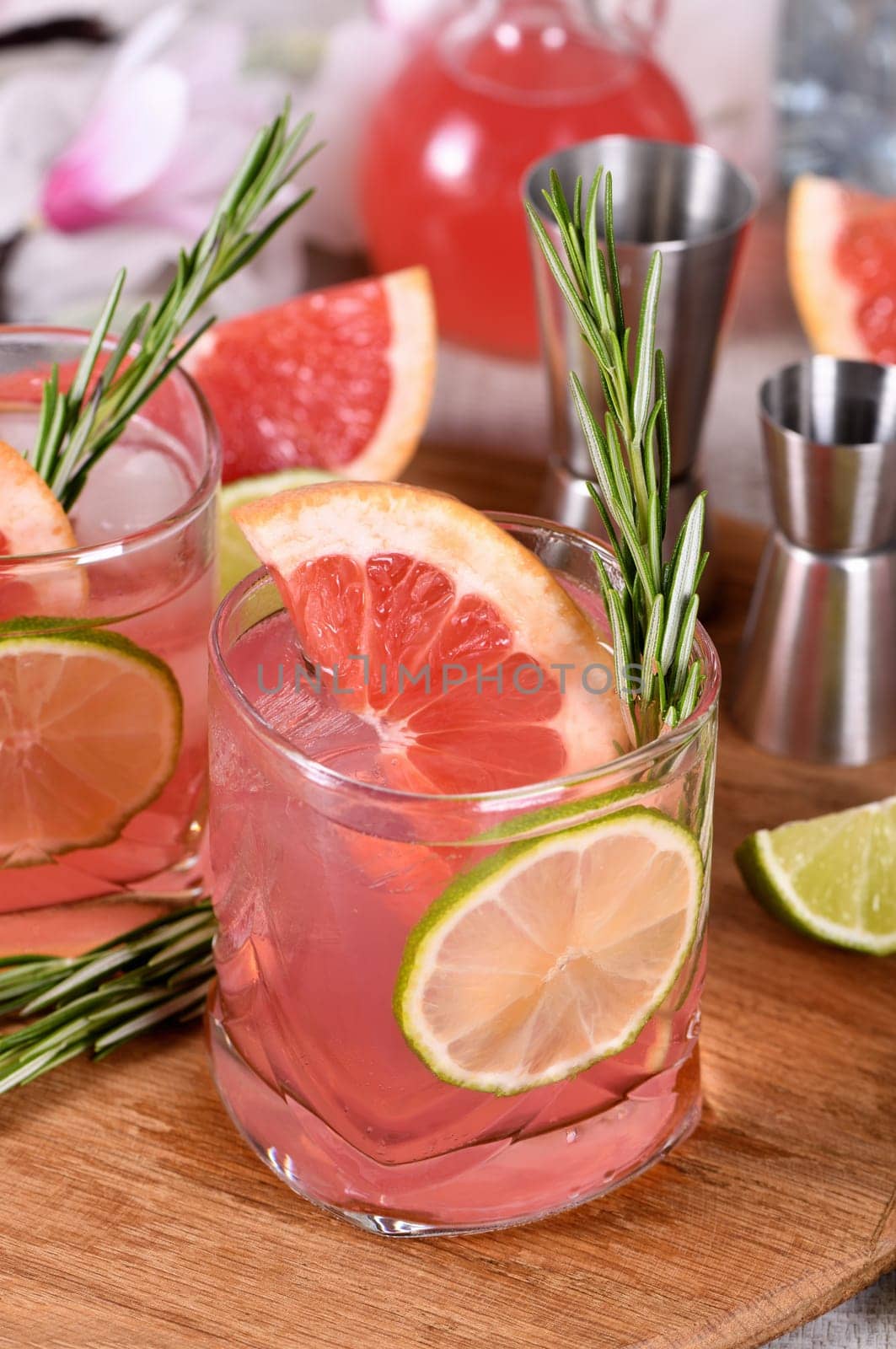 Refreshing organic cocktail with grapefruit slice, lime and rosemary sprig in a glass