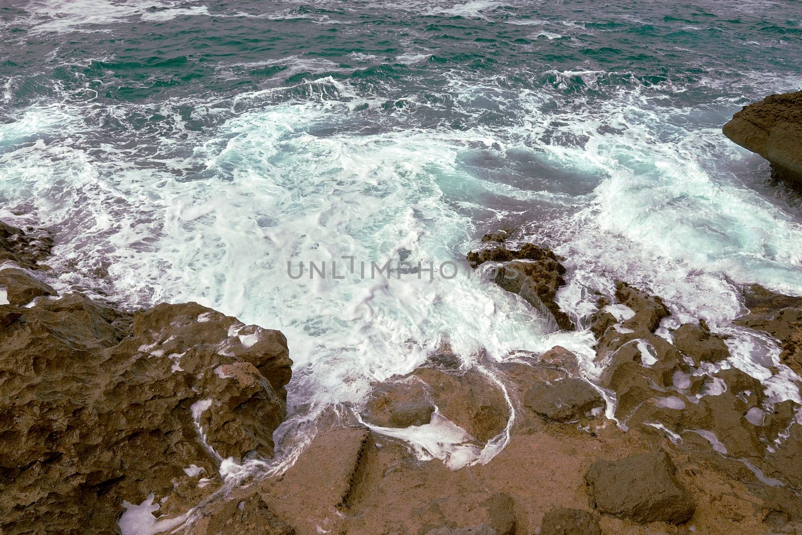 Waves breaking on the rocks at the shore of the beach by raul_ruiz