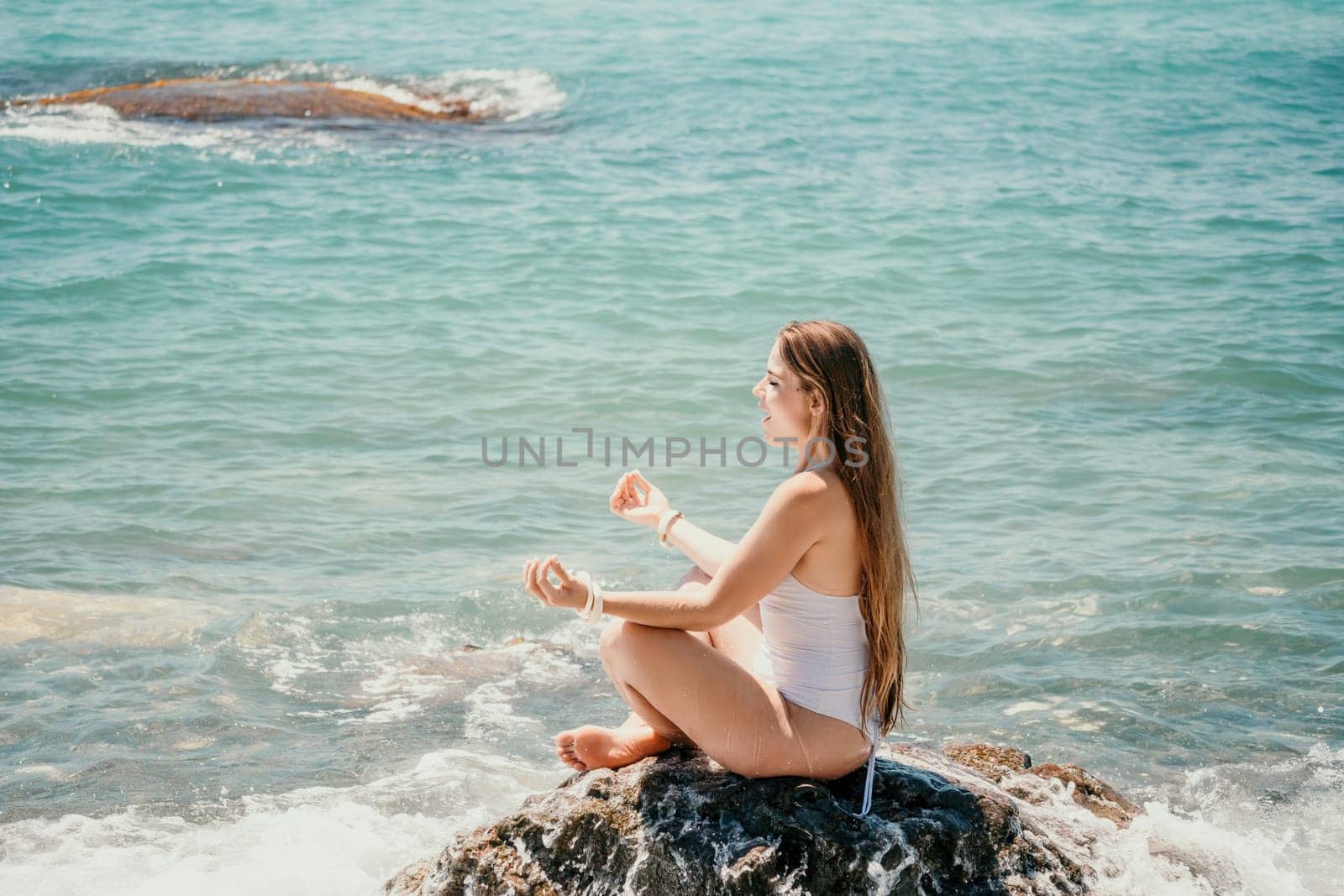 Close up Yoga Hand Gesture of Woman Doing an Outdoor meditation. Blurred sea background. Woman on yoga mat in beach meditation, mental health training or mind wellness by ocean, sea by panophotograph