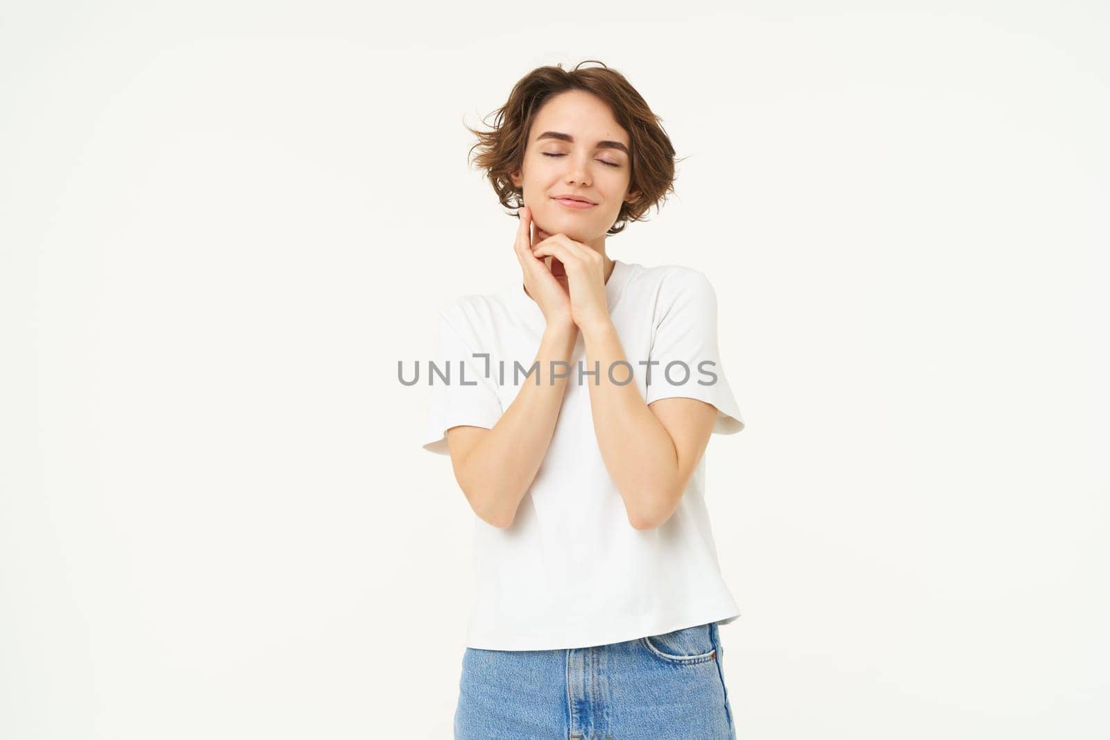 Portrait of carefree girl, gentle and feminine woman with short hair, laughing, posing over white studio background. Copy space