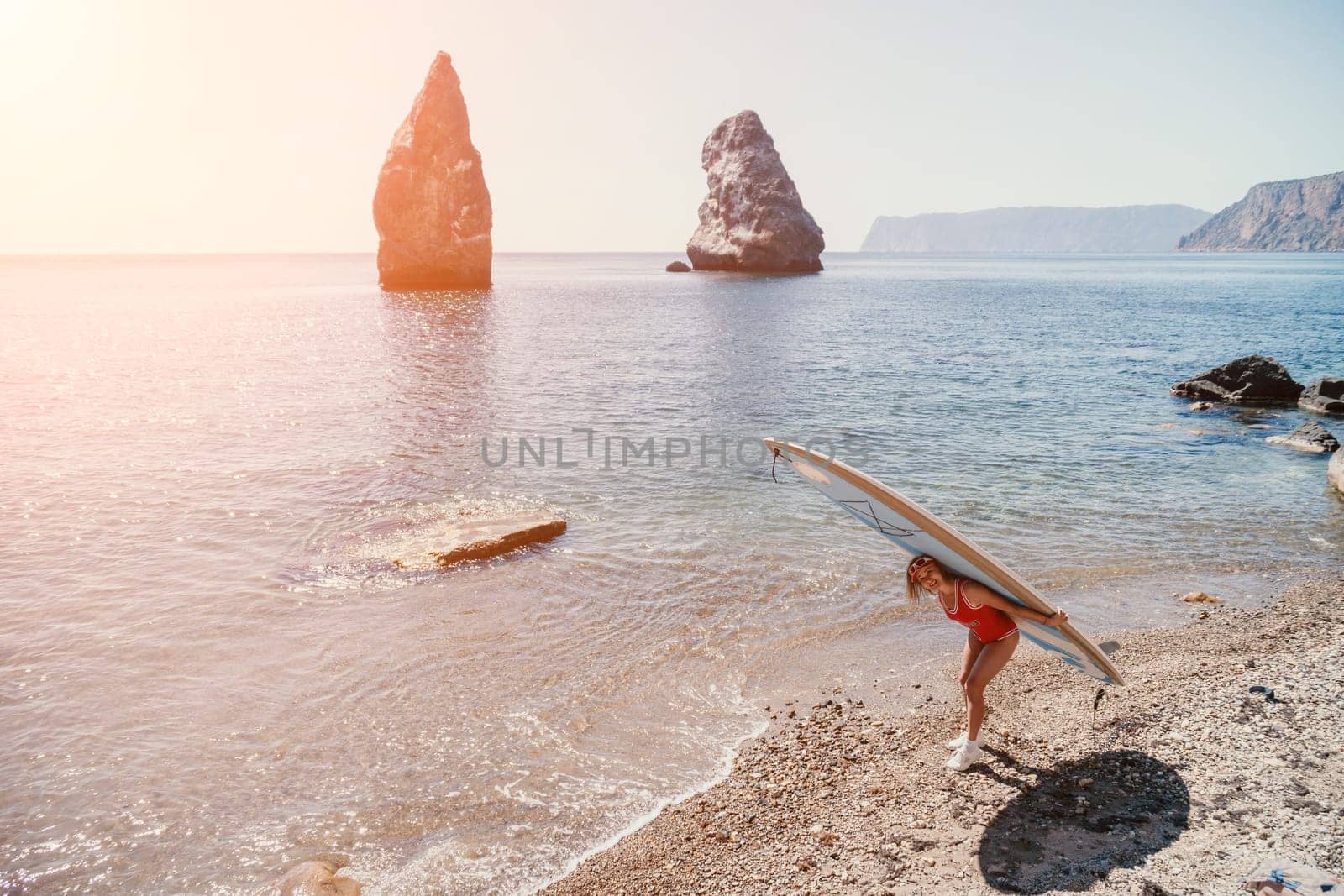 Woman sea sup. Close up portrait of happy young caucasian woman with blond hair looking at camera and smiling. Cute woman portrait in red bikini posing on sup board in the sea by panophotograph