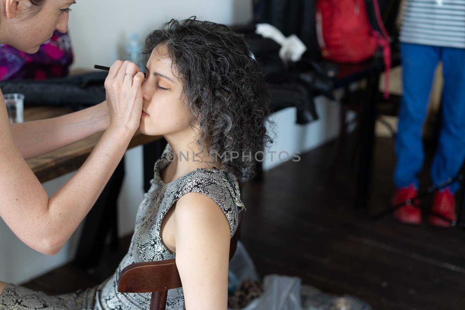 young beautiful woman doing makeup for woman