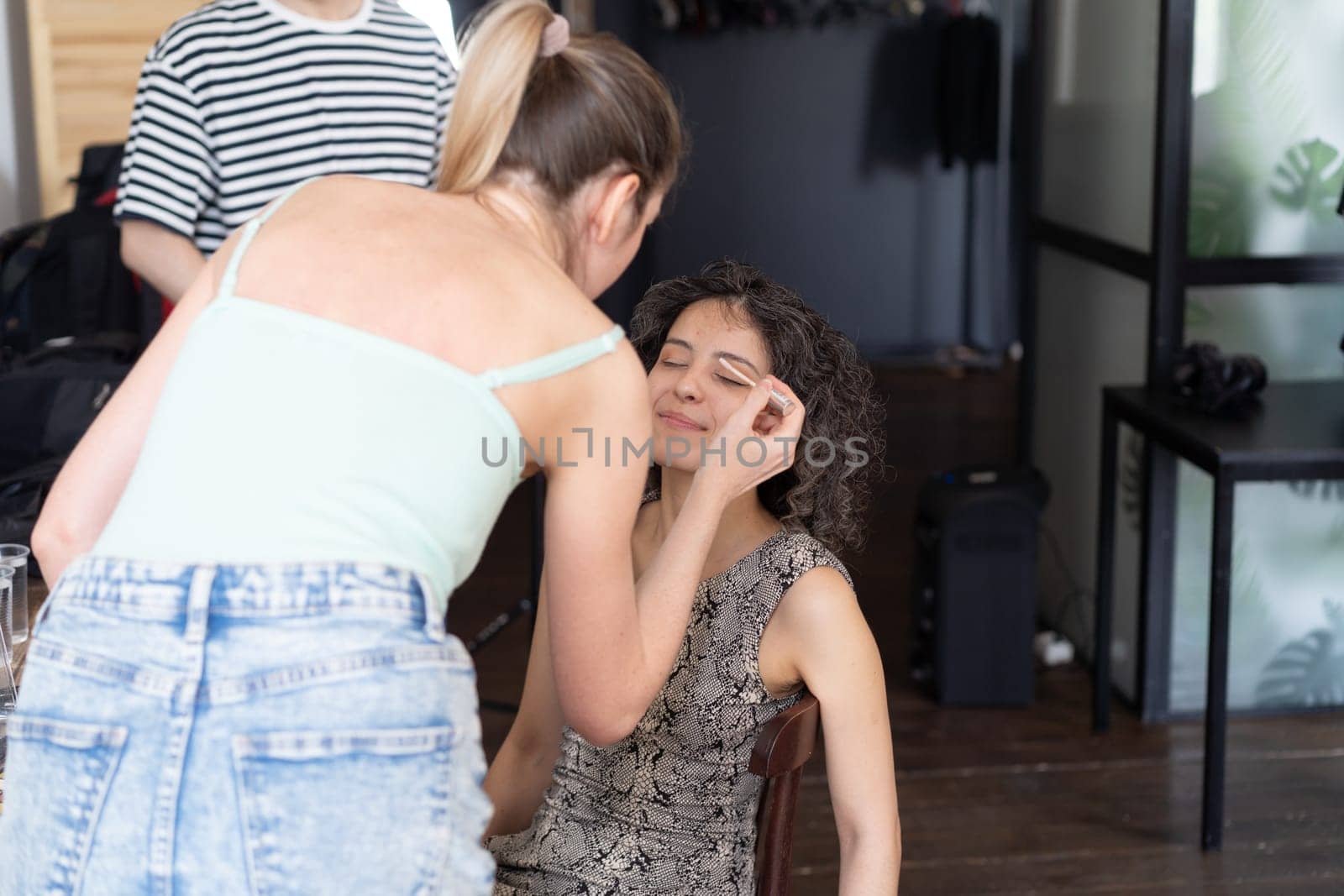 young beautiful woman doing makeup for woman by Igorsmirnof