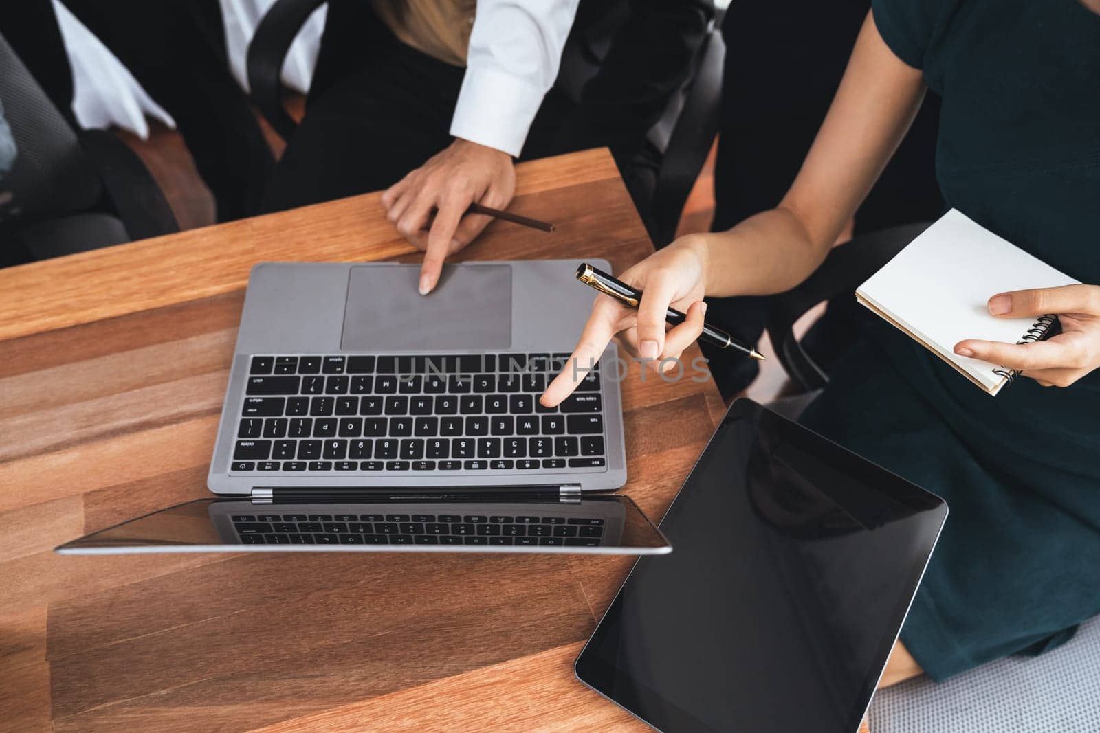 Diverse business people work together, discuss in corporate office. Professional teamwork discussing and pointing at laptop. Modern multicultural office worker. Concord