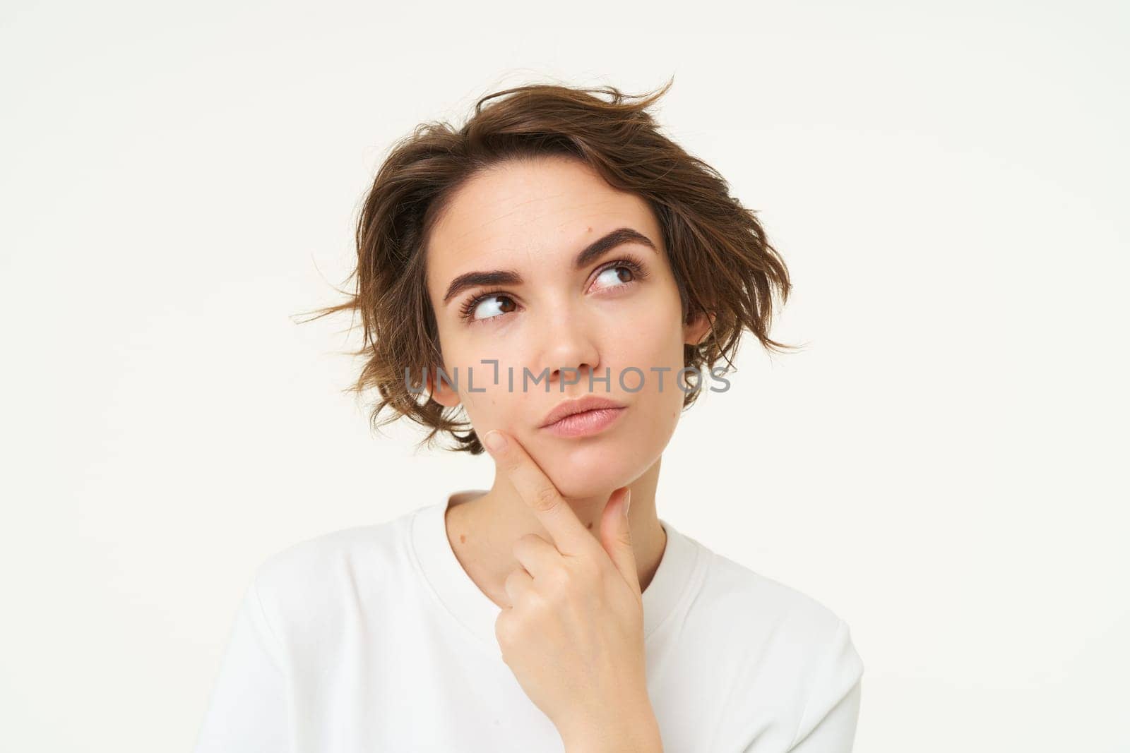 Close up portrait of woman with thoughtful face, thinking of solution, pondering, making choice, standing over white studio background.