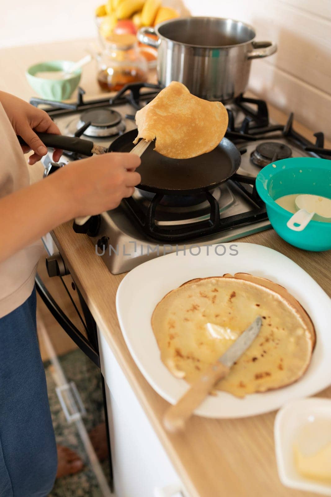 a woman makes pancakes on a griddle.